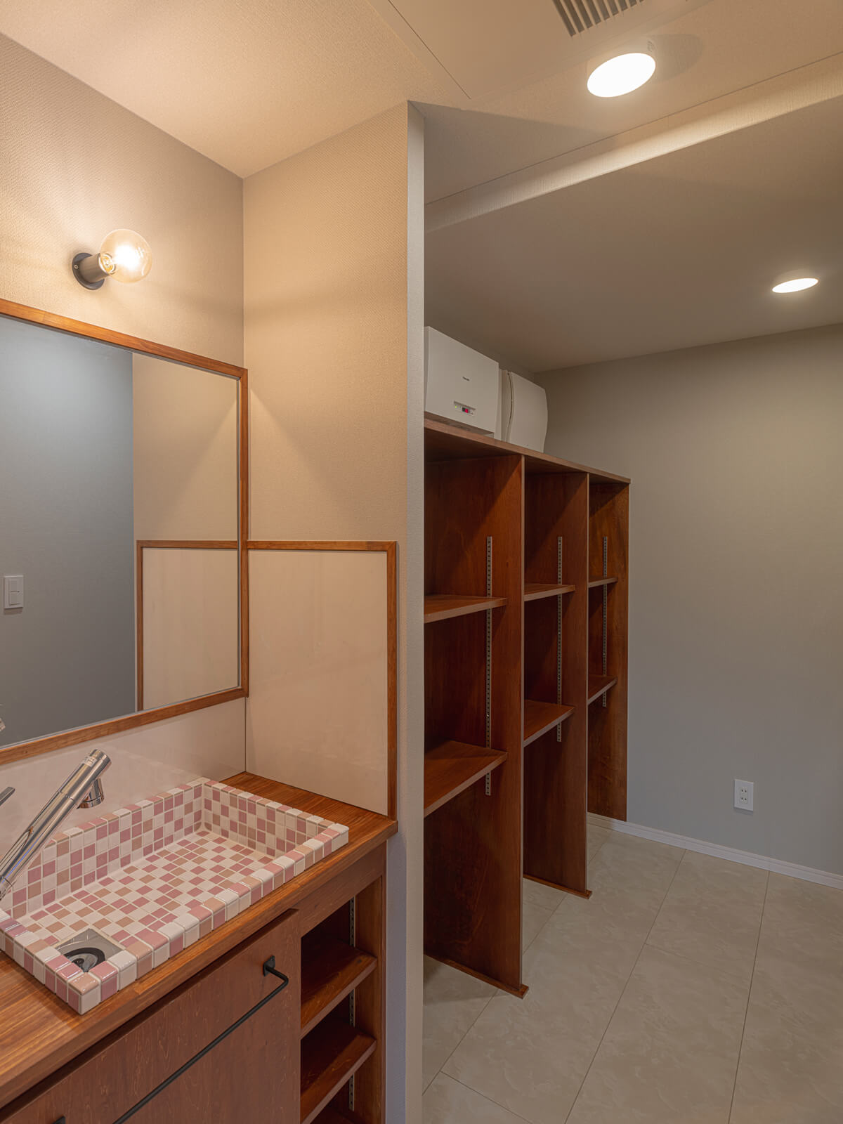 タイル使いが素敵な洗面スペースの奥に広々としたバックヤードがつながる