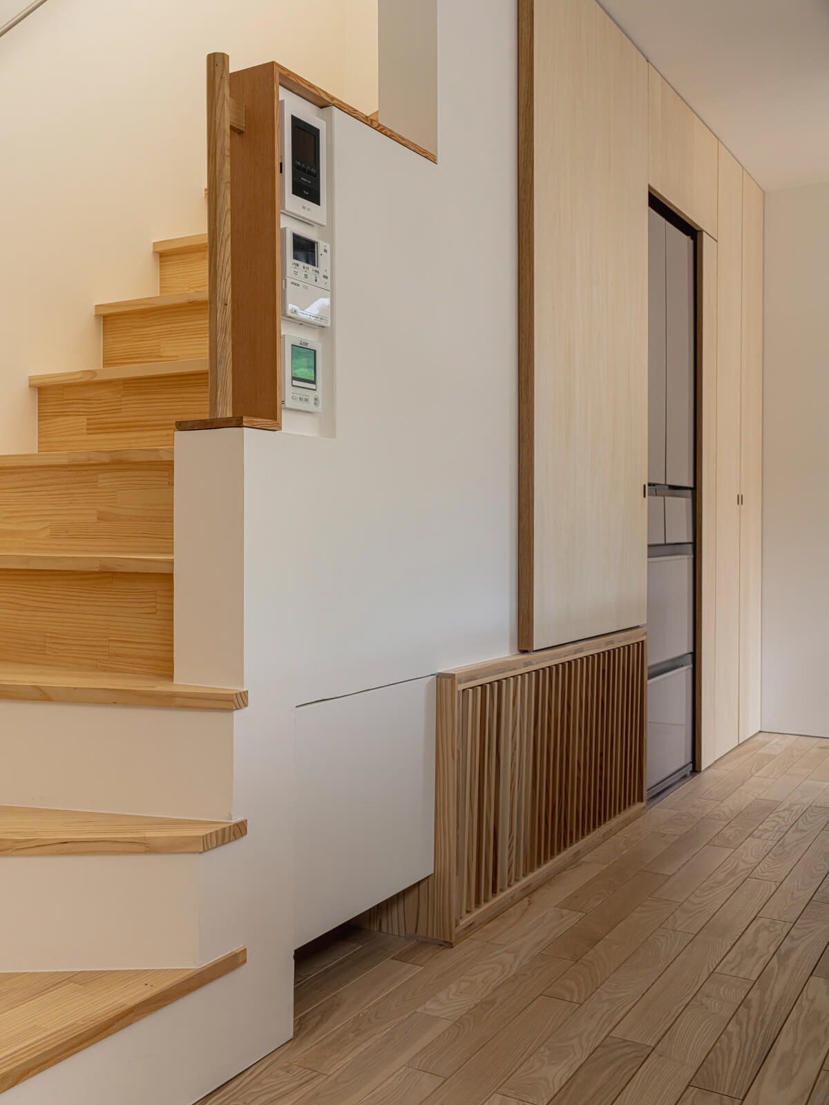 暖冷房用のエアコンは1階と2階に1台ずつ設置。1階は階段下に埋め込まれており、基礎を通って床のガラリから温風を送り込む「床下エアコン」