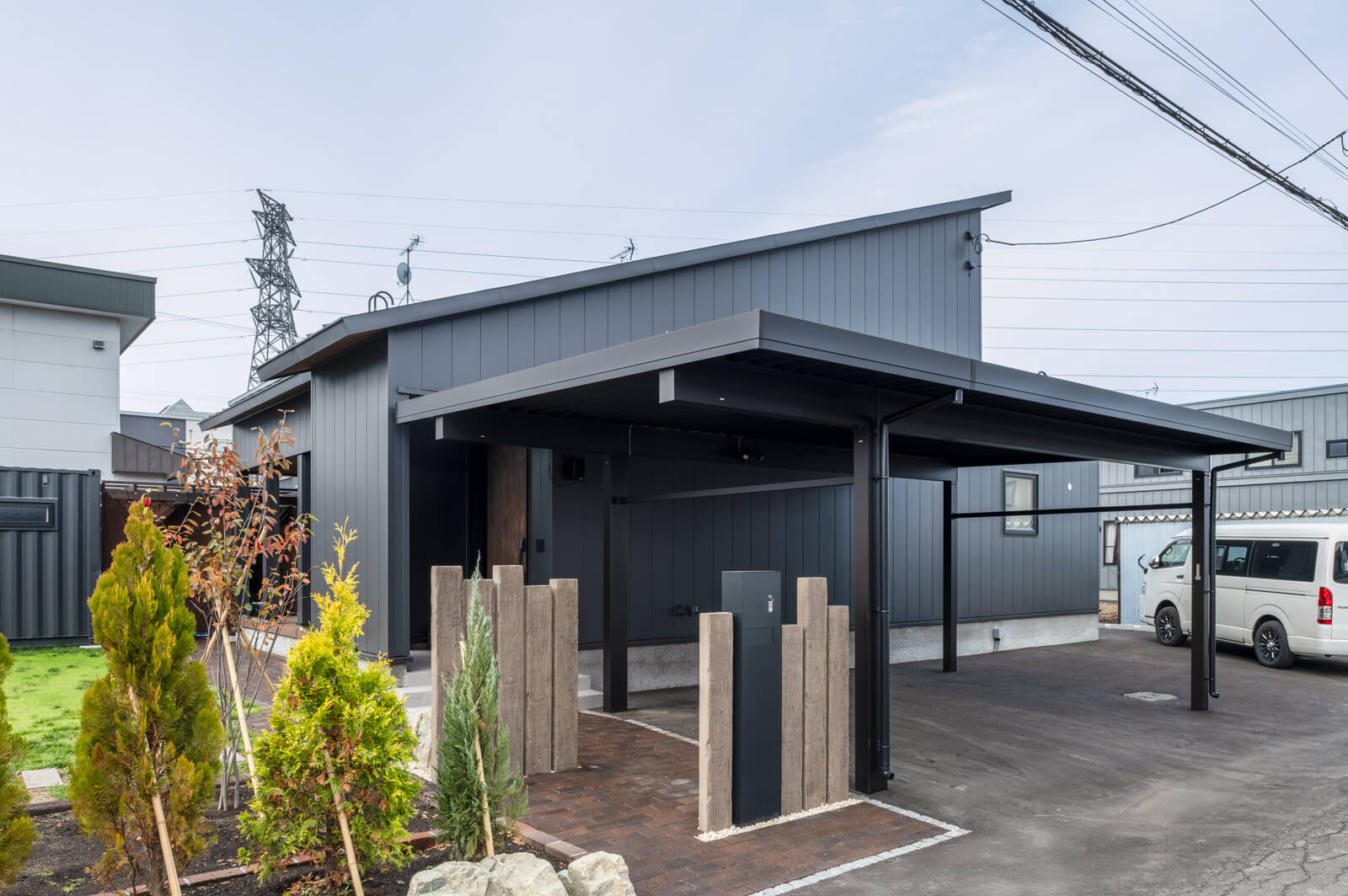 大きな片流れ屋根が印象的なファサード。カーポートの屋根をアプローチの上まで伸ばして、雨雪がしのげるようになっている