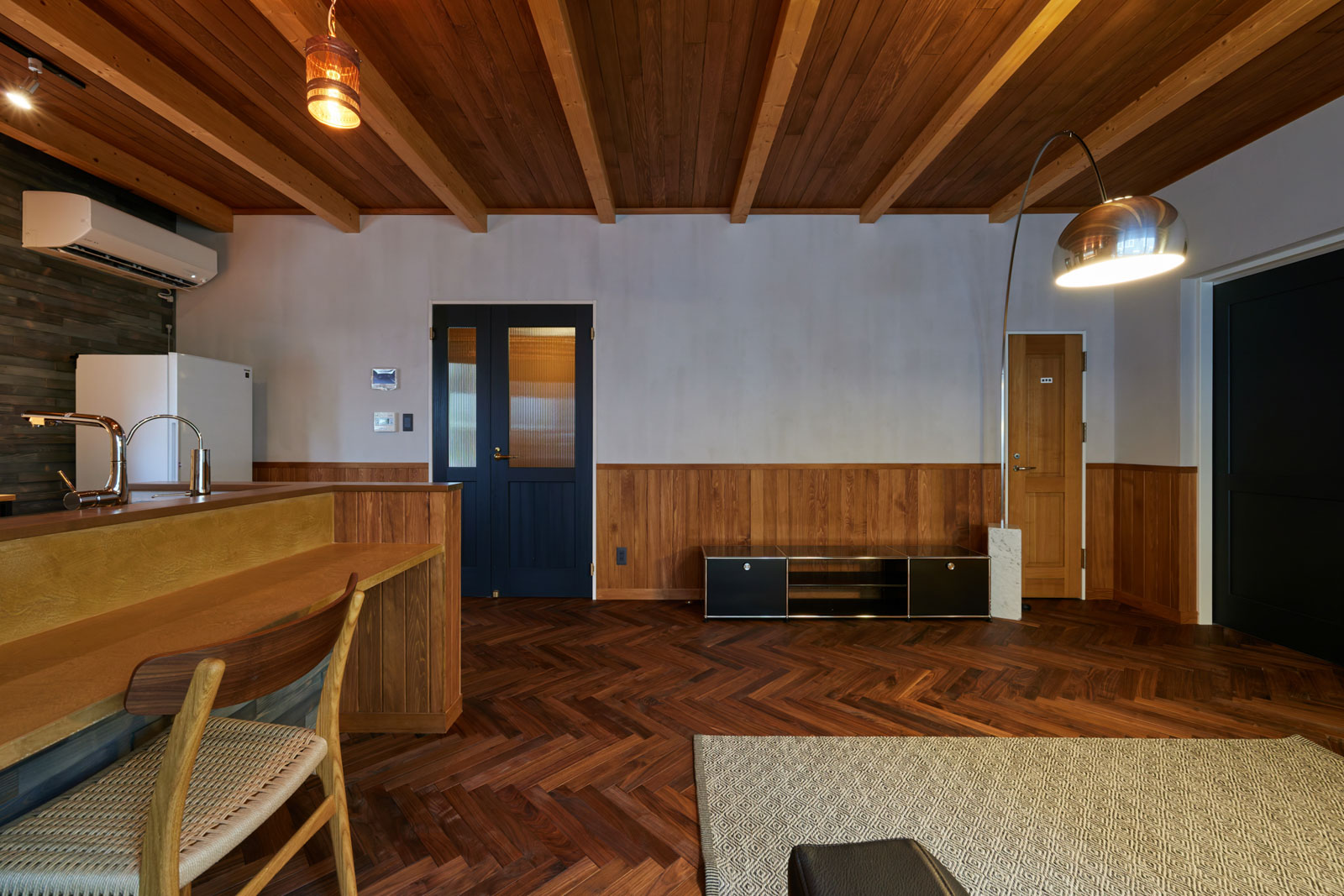 趣味空間の入り口に配したネイビーのドアもMさんのお気に入り。天然素材を使った塗り壁は、化学物質にアレルギーがあるMさんの希望。桧山建設綜業の提案で土佐漆喰を採用した。土佐漆喰は石灰とワラ、水を練って3ヵ月以上熟成させた左官材。石灰は塩を加えて焼くことで不純物を取り除いている