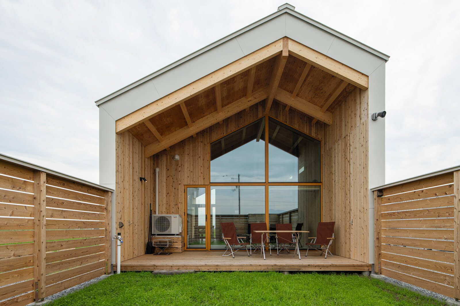 芝ではなくクローバーを敷き詰めた広いドッグランも、このコテージの大きな魅力。軒の出が深いウッドデッキでは、バーベキューなども楽しめる