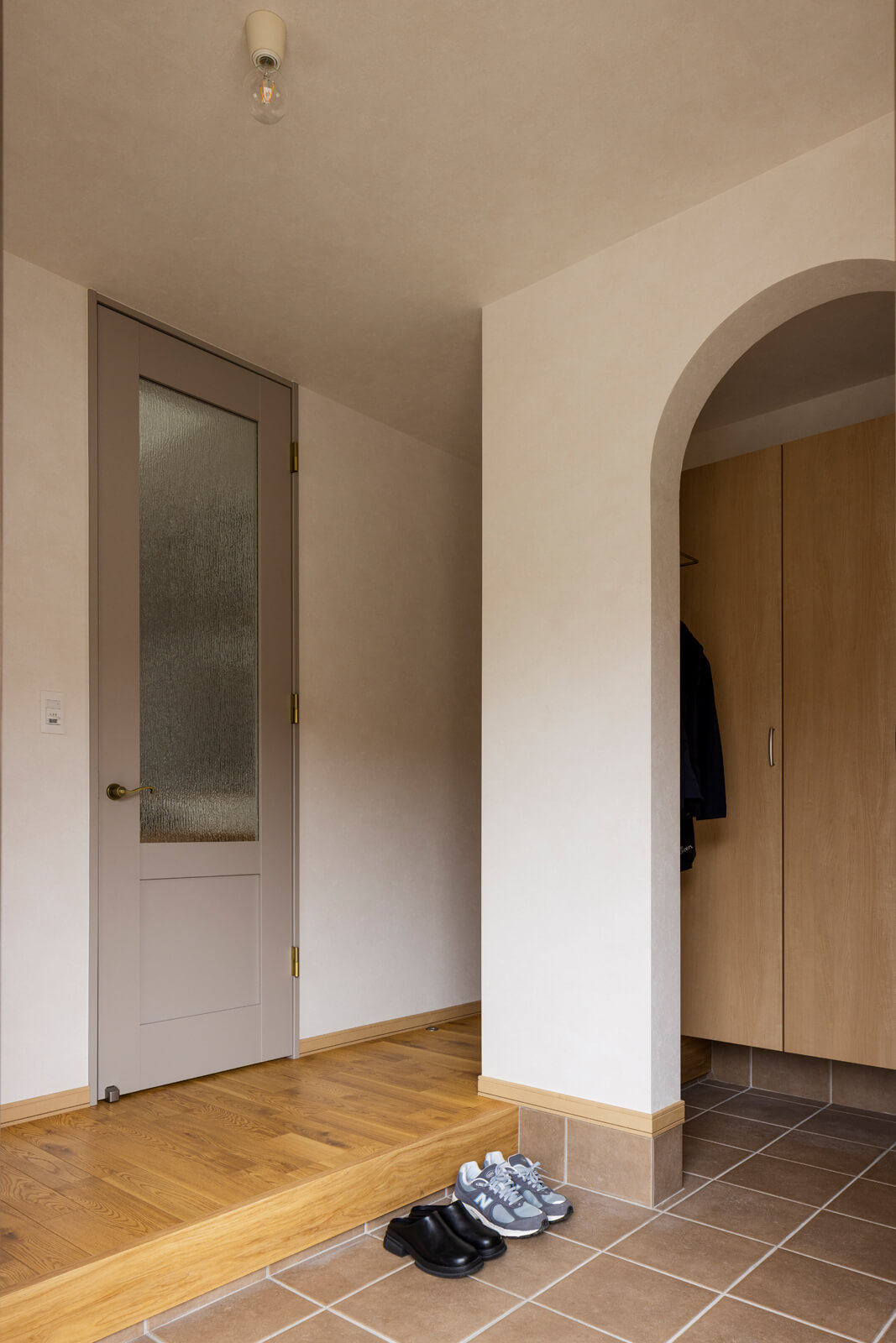 ゆったりと設えた玄関には、出入り口にアールのデザインを施し容量たっぷりのシューズクロークも備えた家族用玄関を設けた