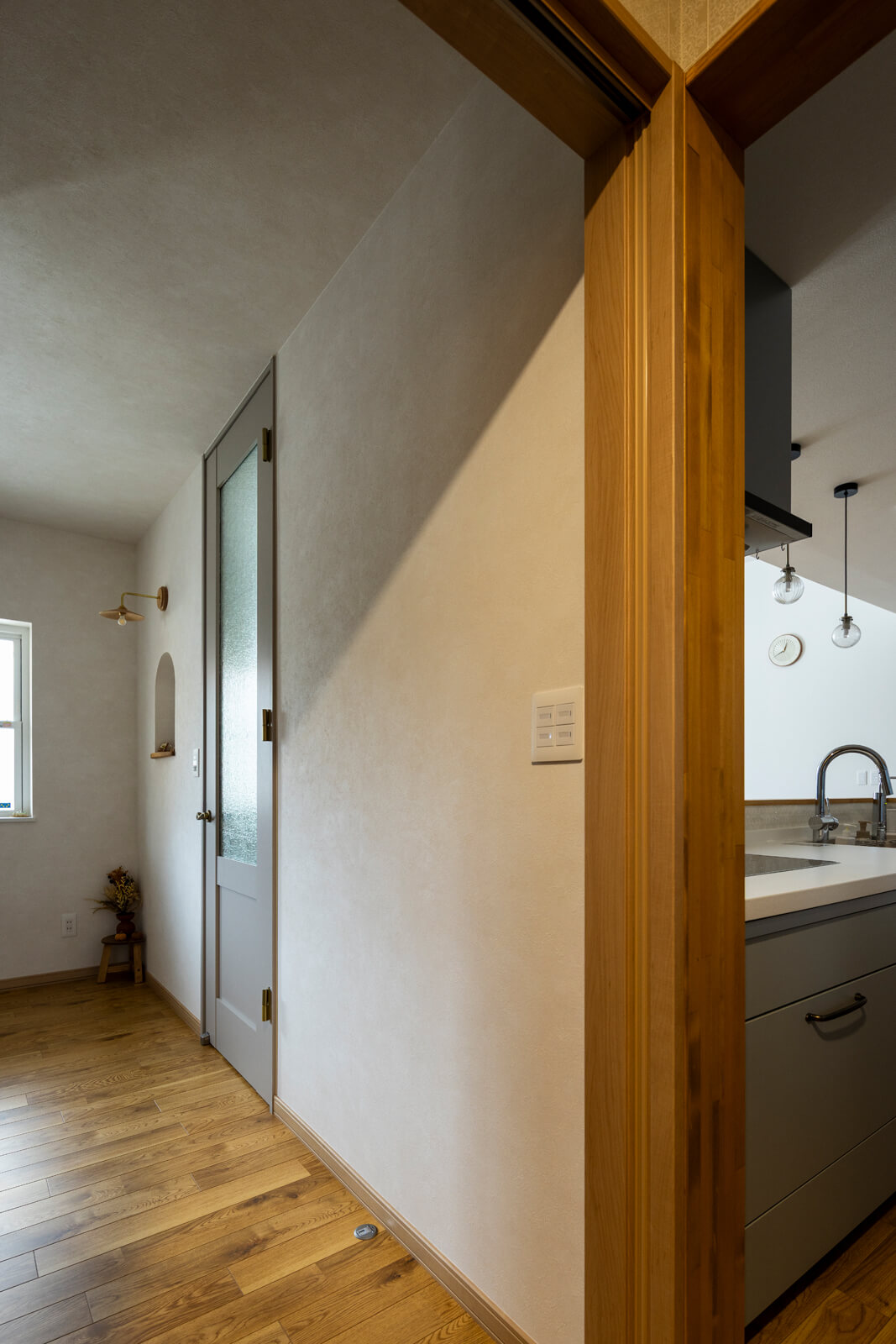 玄関ホールはリビング、パントリー＆キッチンの2方向につながる回遊動線を採用。リビングのドアは、KAMIYAのハイドアを採用