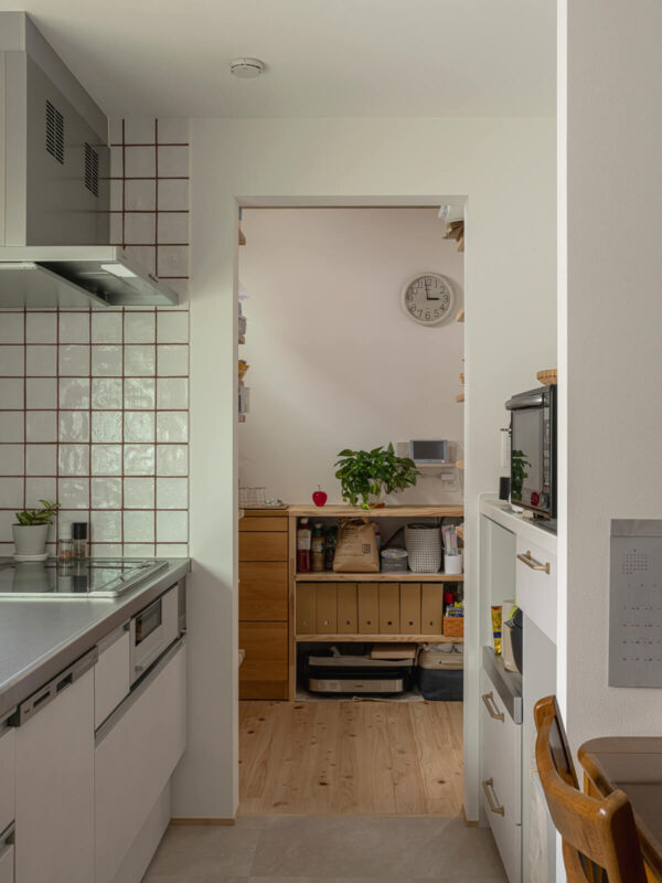 キッチンの壁は奥さんお気に入りのタイルを張って仕上げた。玄関からパントリーを通ってキッチンへ直行できる動線は、買い物帰りなどに便利