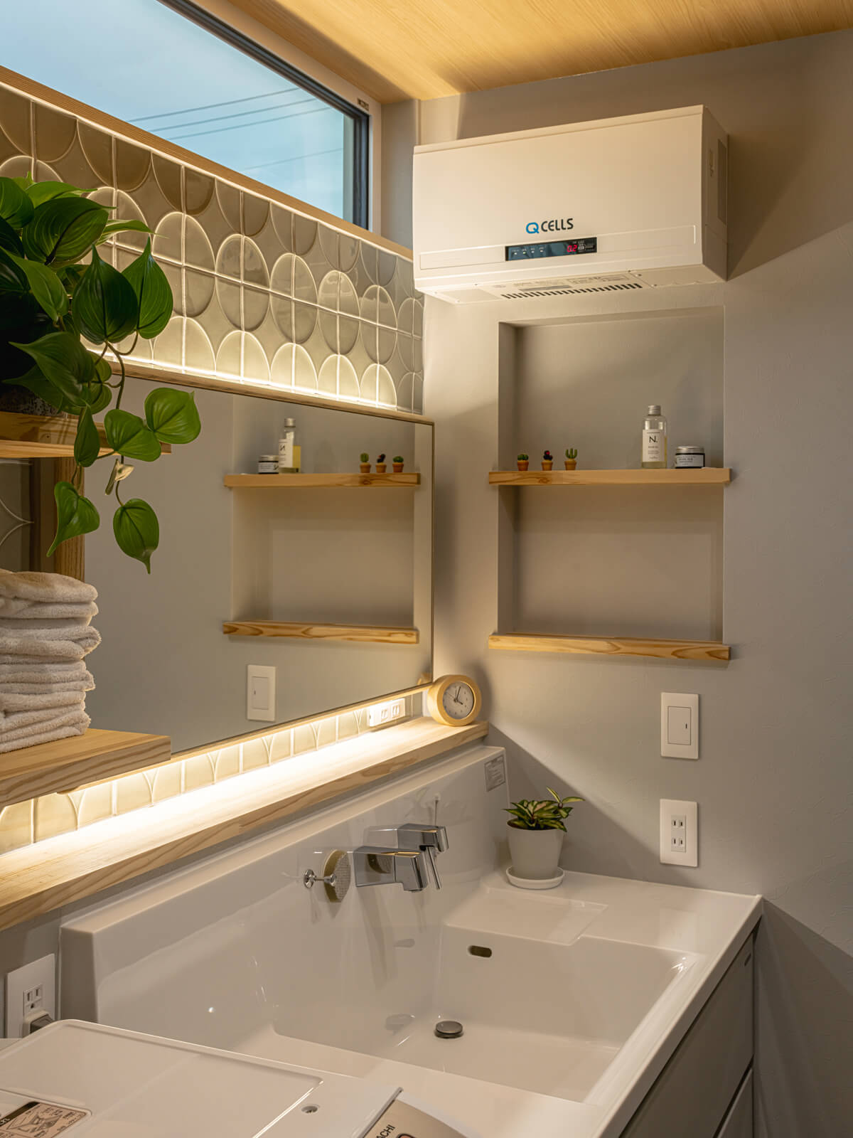 お二人がネットで探したという木製フレームのミラーの後ろには間接照明を組み込んだ