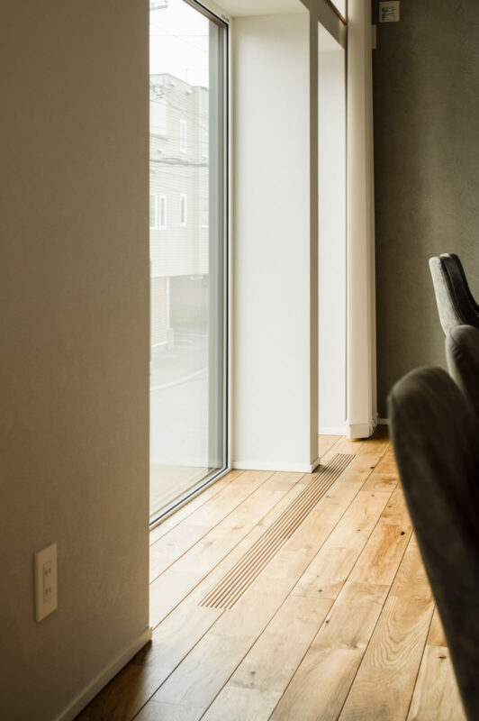 無垢床になじむ窓辺の木製ガラリを介して、暖気や冷気が行き来する。壁の厚みからも高い断熱性能がうかがえる