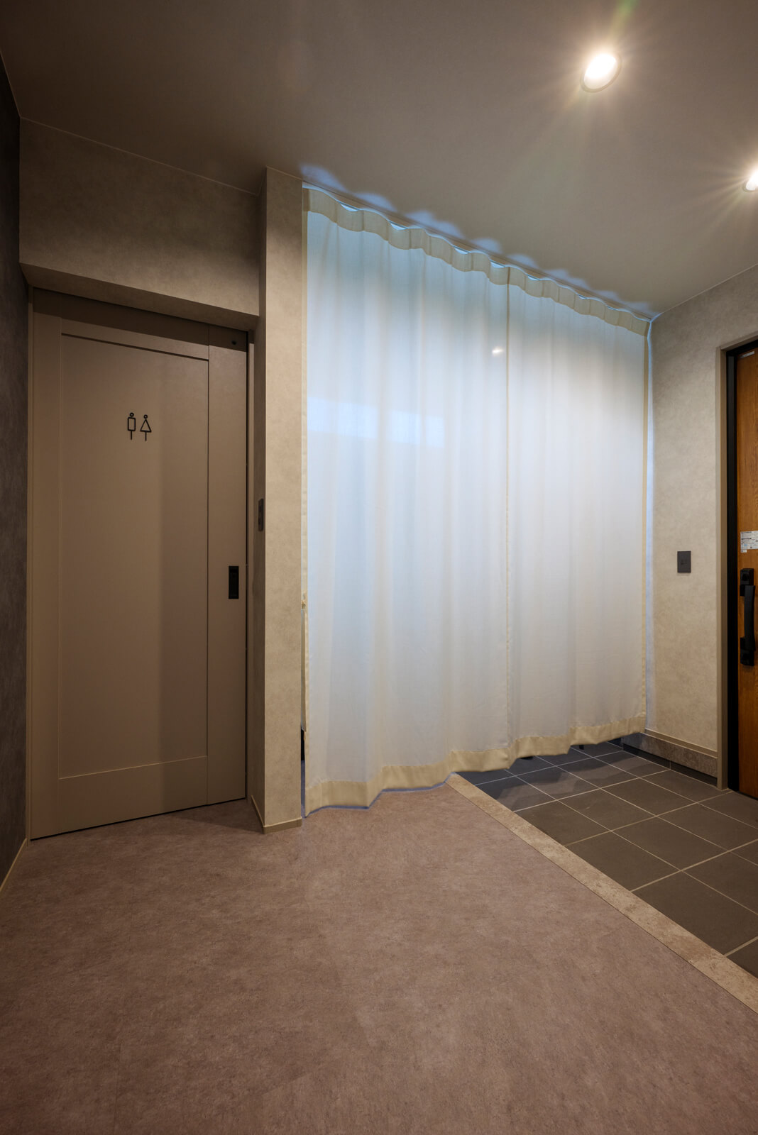 約6帖の広々とした玄関ホール。一般的には壁で仕切られたシュークローゼットが設計される空間は、奥さんのアイデアからカーテンで目隠ししたフリーの収納スペースとした