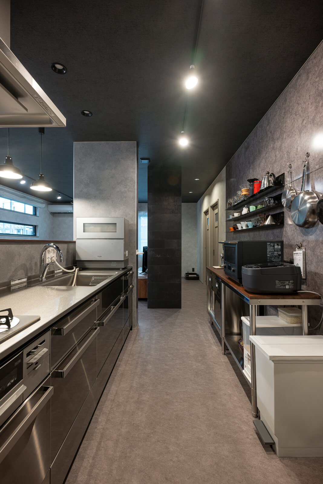 ステンレスで統一したキッチン。石目の床や壁と調和して、ご夫妻が要望するインダストリアルなデザインにまとまっている