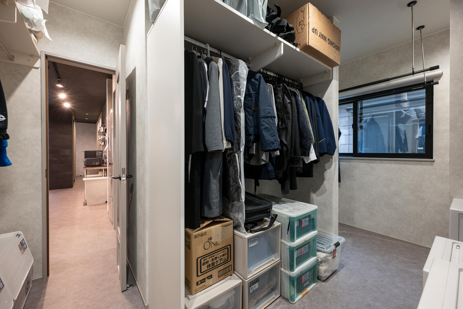 右手奥のユーティリティからファミリークローゼットを通って左奥のキッチンへ抜ける回遊型の間取りは、短い家事動線で作業を効率化する