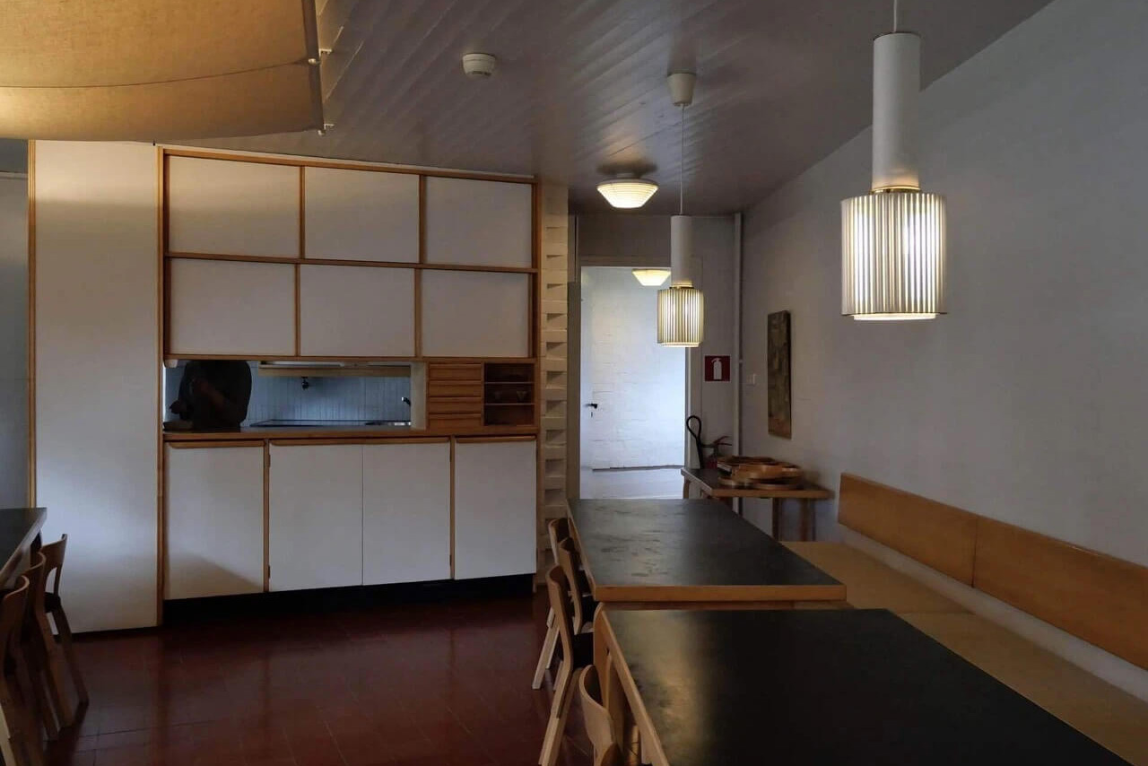 階段からの光が白い壁を明るく照らす。食器棚の奥には今でも現役のキッチンがある。ここに設計士たちが食べるランチが並んだそう