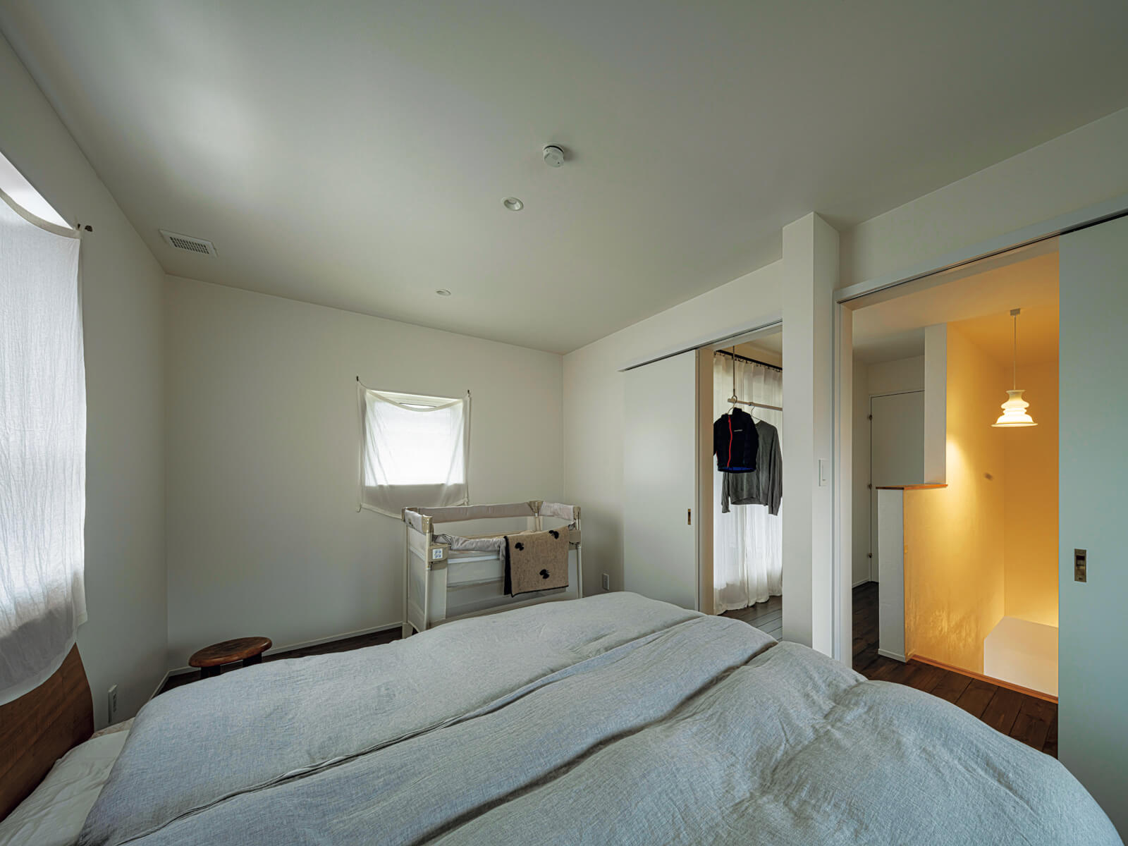 白色でシンプルにコーディネートされたこの部屋は子ども室として設計されたが、今は家族4人の寝室に。階段ホールの一角は物干しスペース