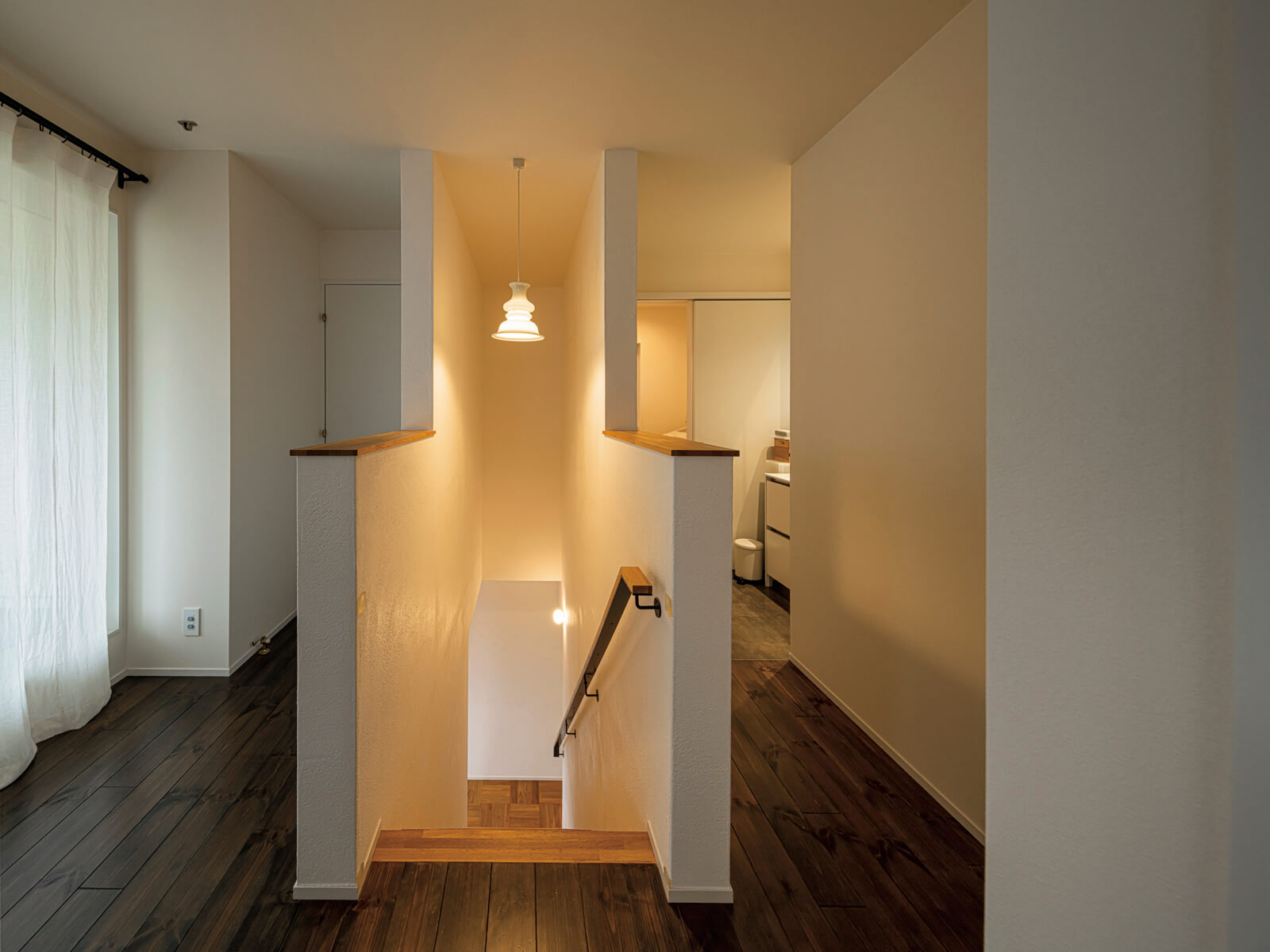 HOLMEGAARD(ホルムガード)のビンテージ照明が、シンメトリーにデザインされた階段室をやわらかく照らす