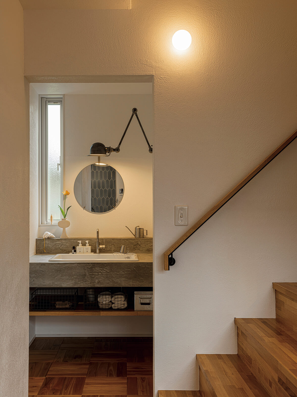 洗面スペースは回遊動線上にレイアウト。洗面台は造作で、奥さんがどこかに使いたかったというJIELDE(ジェルデ)の壁付け照明を取り付けた