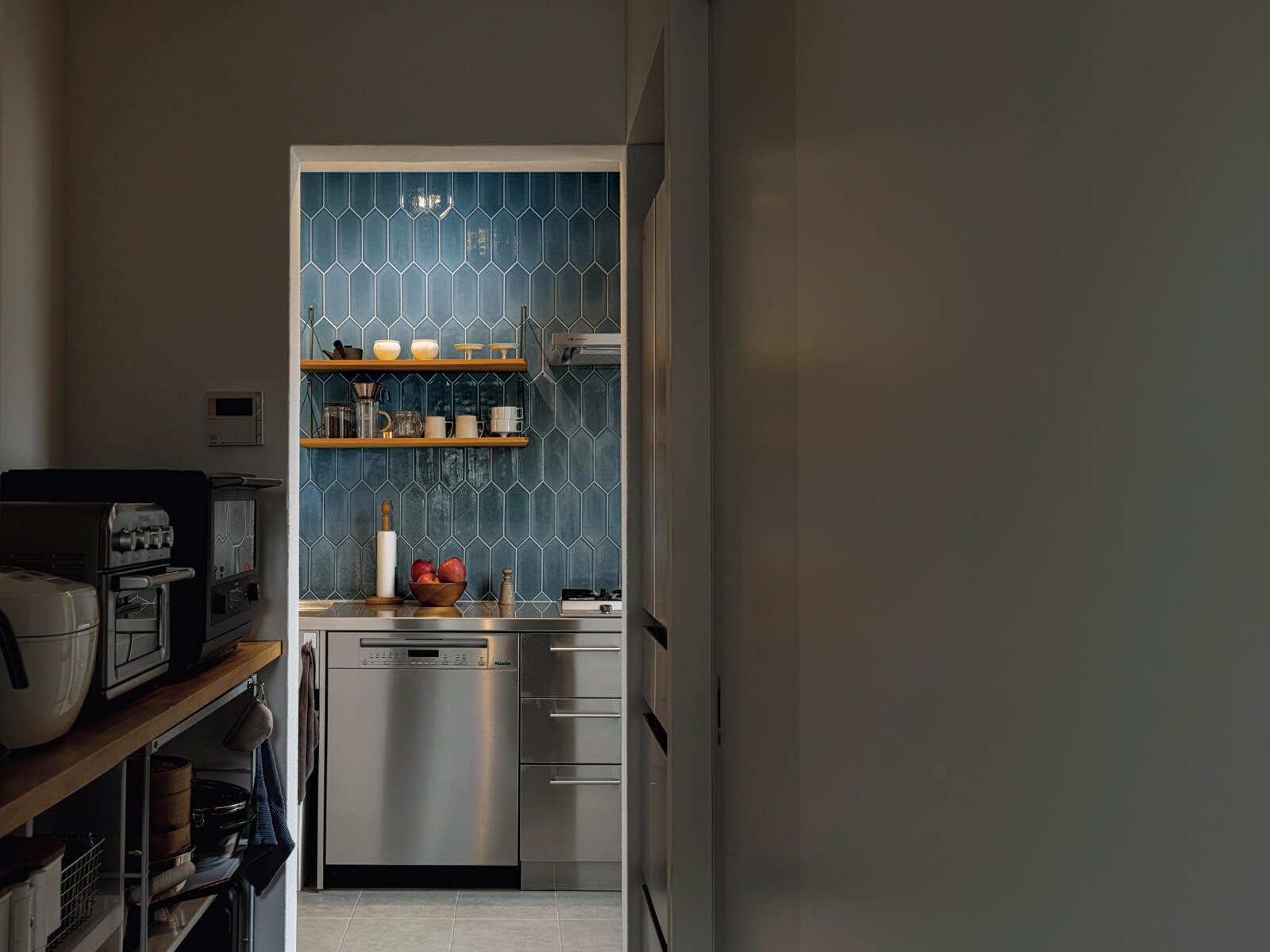 冷蔵庫や調理家電、食器類などは、パントリーの中にまとめて収納し、インテリア性にこだわったキッチンまわりの生活感を感じさせないようデザインされている