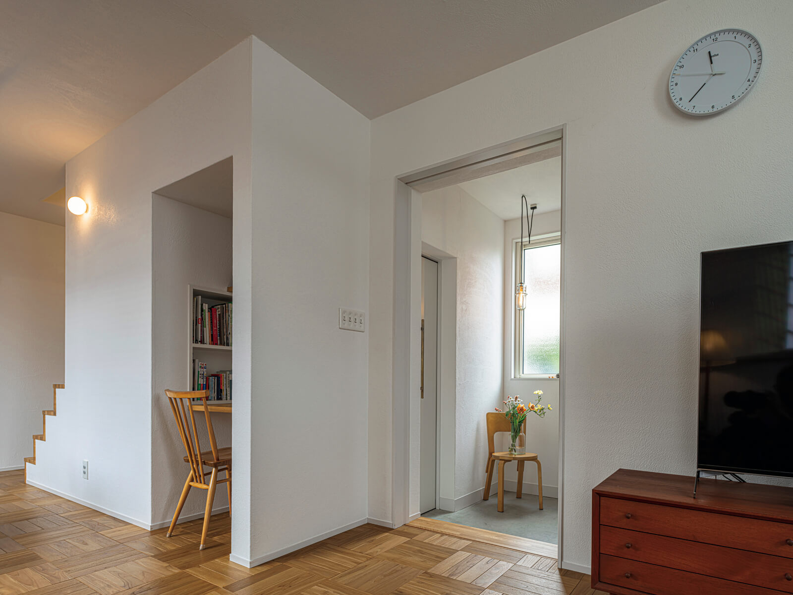 玄関はリビングとダイレクトにつながる設計。階段下のデッドスペースはカウンターや棚を造作してワークスペースにし、限りある空間を最大限に有効活用