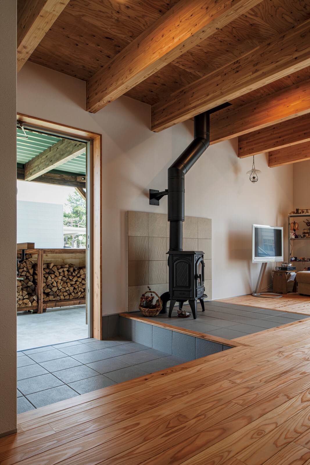 最短距離で結ばれたカーポートに設置した自作の薪棚と薪ストーブ。薪の持ち運びもスムーズでストレスなく冬の暮らしを楽しむことができる