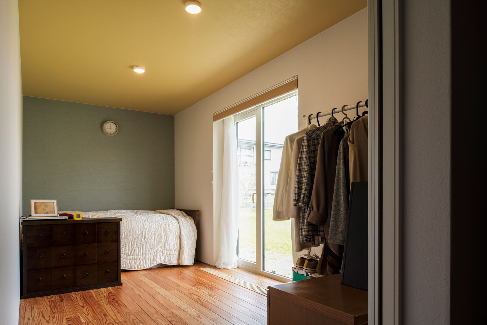 個室の天井は黄色のクロスとし、LDKとは異なる趣に。さらに奥さんの個室は壁の一部に青緑のクロスを採用してアクセントをつけている