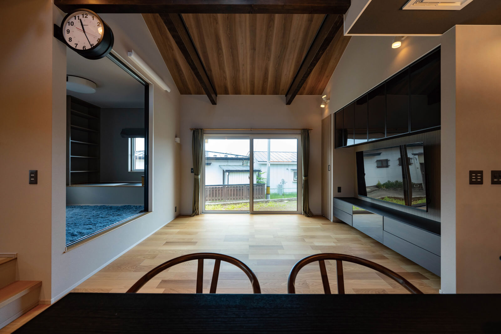 リビングは幅いっぱいの大きな窓が奥行きをもたらし、実際よりも広く感じさせる。「部屋が狭く見える、掃除がしにくいなどの理由からソファは置きたくないけれど、くつろげる空間にしたい」というご夫妻の希望で、ソファの代わりに腰かけられる高さ40㎝の小上がりを配置した