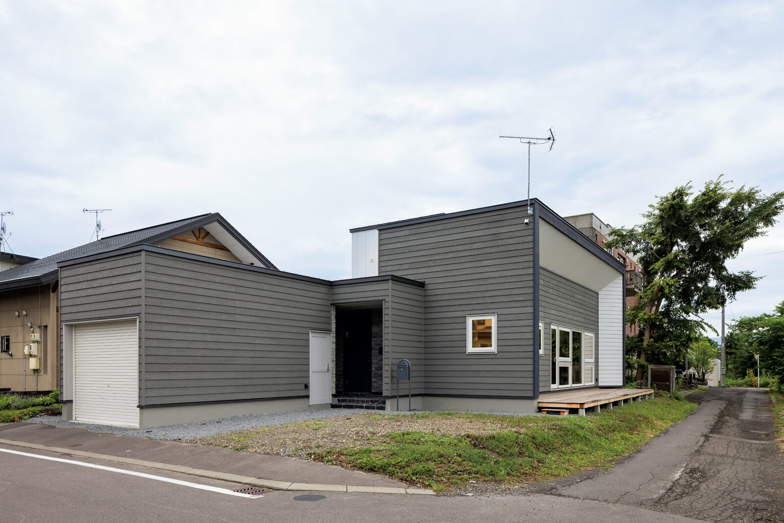 スギ板とガルバリウム鋼板を用いた外観は、グレーと白を基調に整えた。ガレージも併設