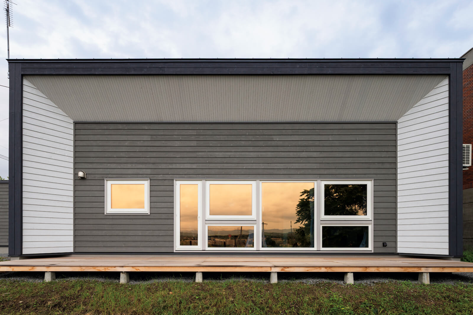 リビング・ダイニングに設えた連続する大開口は、豊かな景色と光、そして風を取り込む役割を果たす。ウチとソトの中間領域となるウッドデッキにも出入りできる