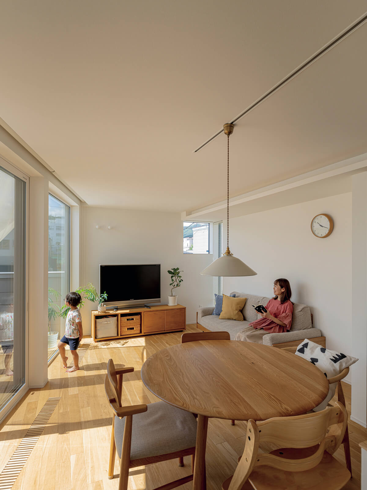 周囲の目線を巧みに遮りながら、緑の景色を室内に取り込んだリビング・ダイニング。バルコニーにつながる大開口が心地よい広がりを演出