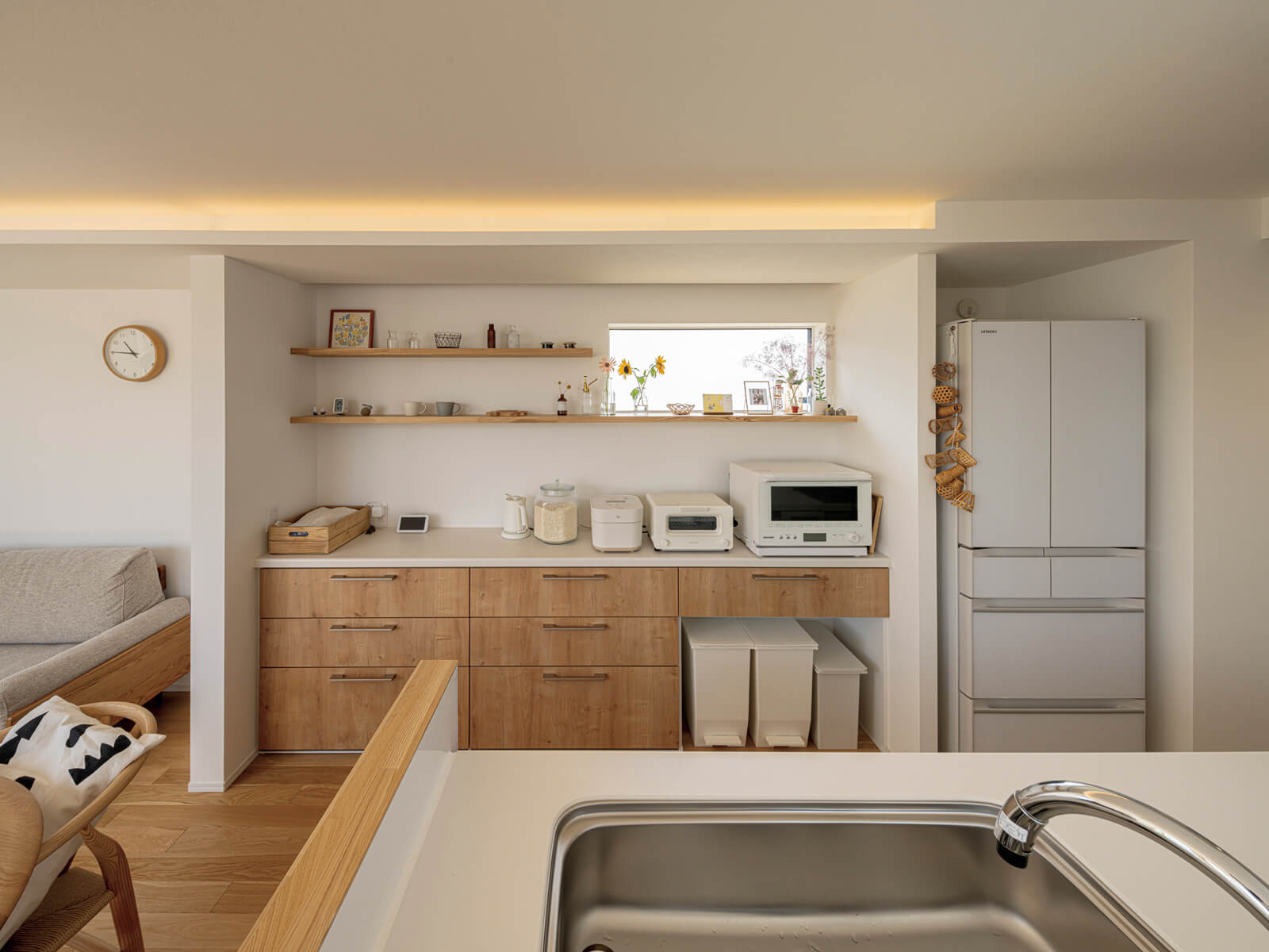 背面収納の面材、棚板にはアカダモを用い、棚受けは壁の中に納めてすっきりと仕上げた