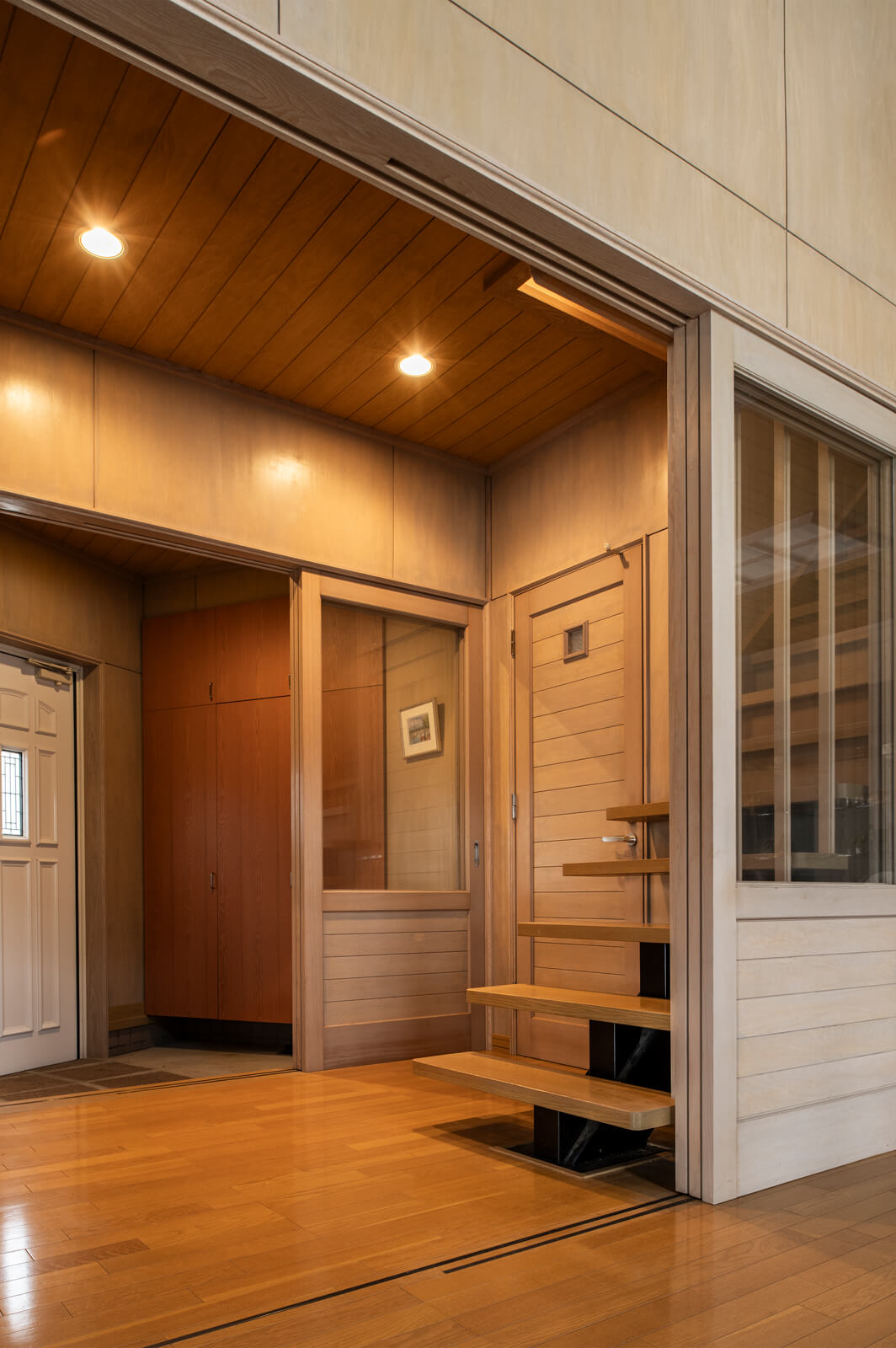 ゆったりとしたつくりの玄関ホール。収納や階段、建具はすべてタモ材を用いた造作