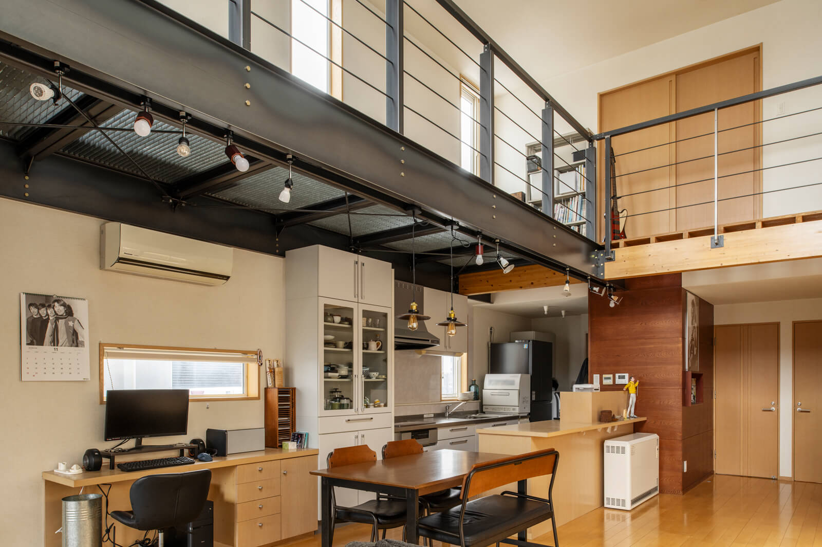 2階階段ホールのキッチン側には、自然光を階下に落とし、おおらかな空間を引き締めるグレーチングと鉄骨梁を採用