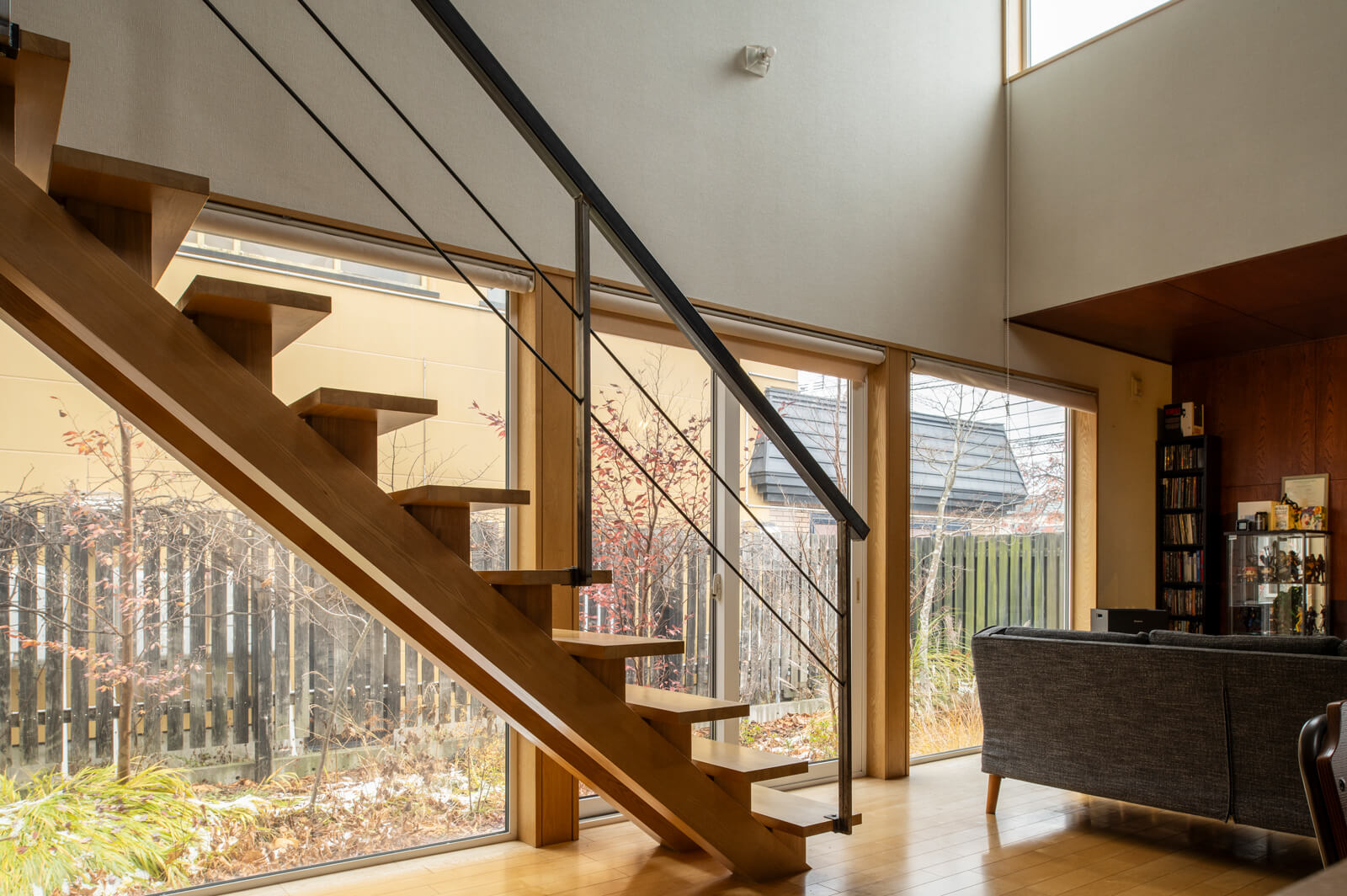 リビングの庭側には大きな3連窓を採用し、室内と外部空間との一体感を演出。夜には庭に設えたスポットライトが草木の影を室内に描き出す