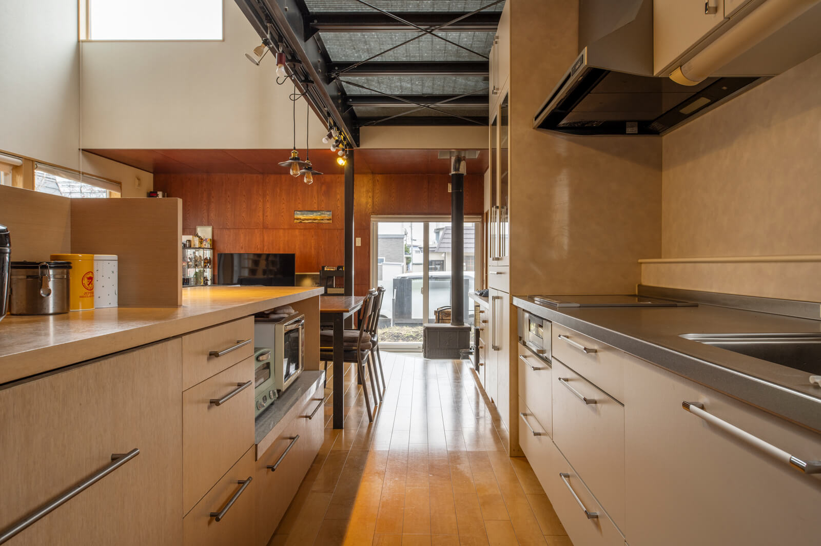 キッチンは壁付けとし、造作カウンター収納でリビングと緩やかに分離。裏動線で納戸、ユーティリティにもつながり、家事動線も抜群