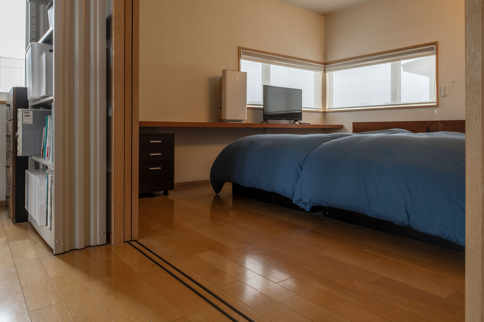 吹き抜けに面して、ウォークインクローゼットも備えた寝室をレイアウト。すっきりと壁に納まる引き戸やL字窓を採用し、明るく開放的なくつろぎ空間を実現