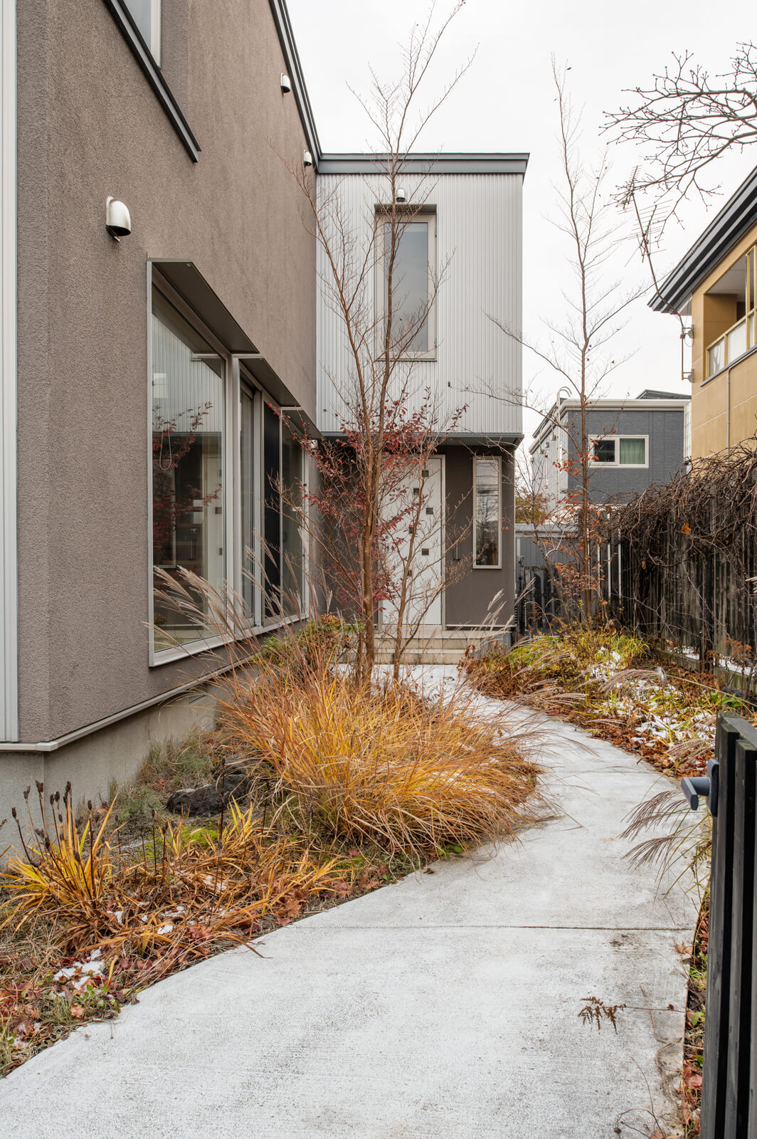 玄関を敷地奥へ配置し、庭を通り抜けるようなアプローチを設えた