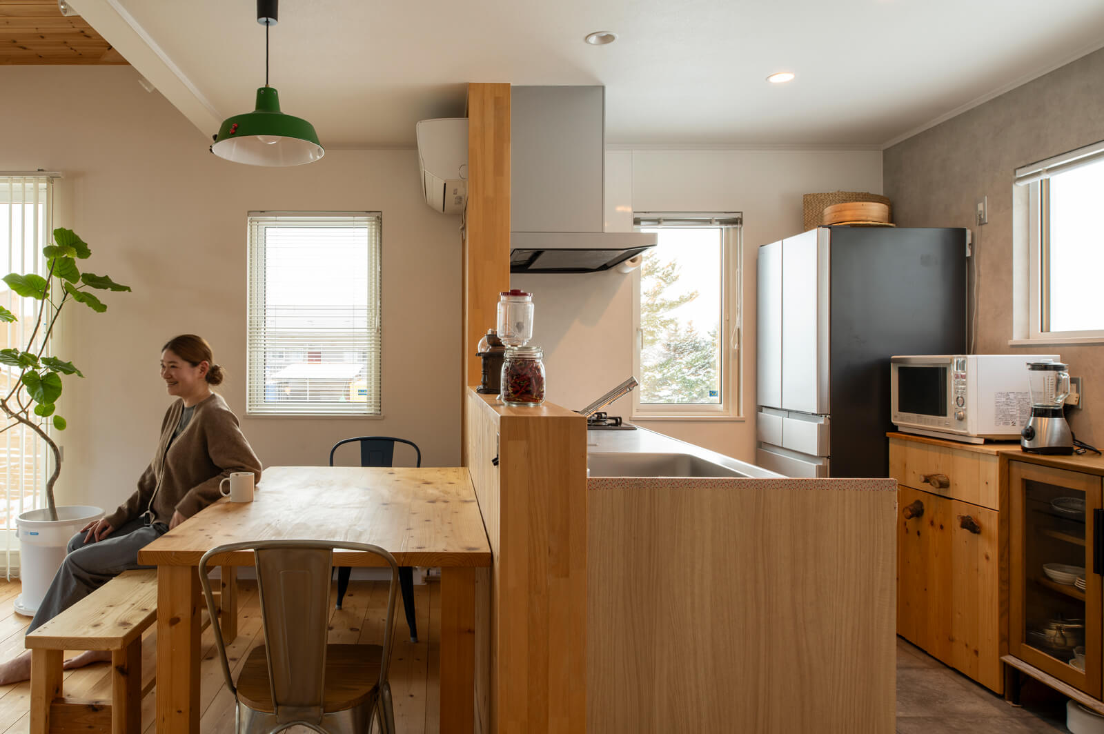 対面式キッチンはメンテナンスのしやすさを重視し、既製のシステムとフロアタイルを採用。背面に設置したレンジ台、キッチン前のダイニングテーブルとベンチはKさんの手づくり