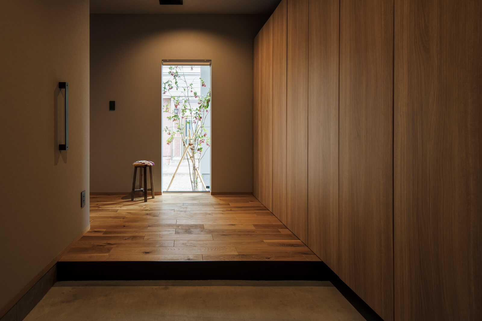 玄関を開けると視線の先に出迎えるシンボルツリー。靴やアウターなどを一手に引き受ける全面収納で、すっきり広々とした空間に