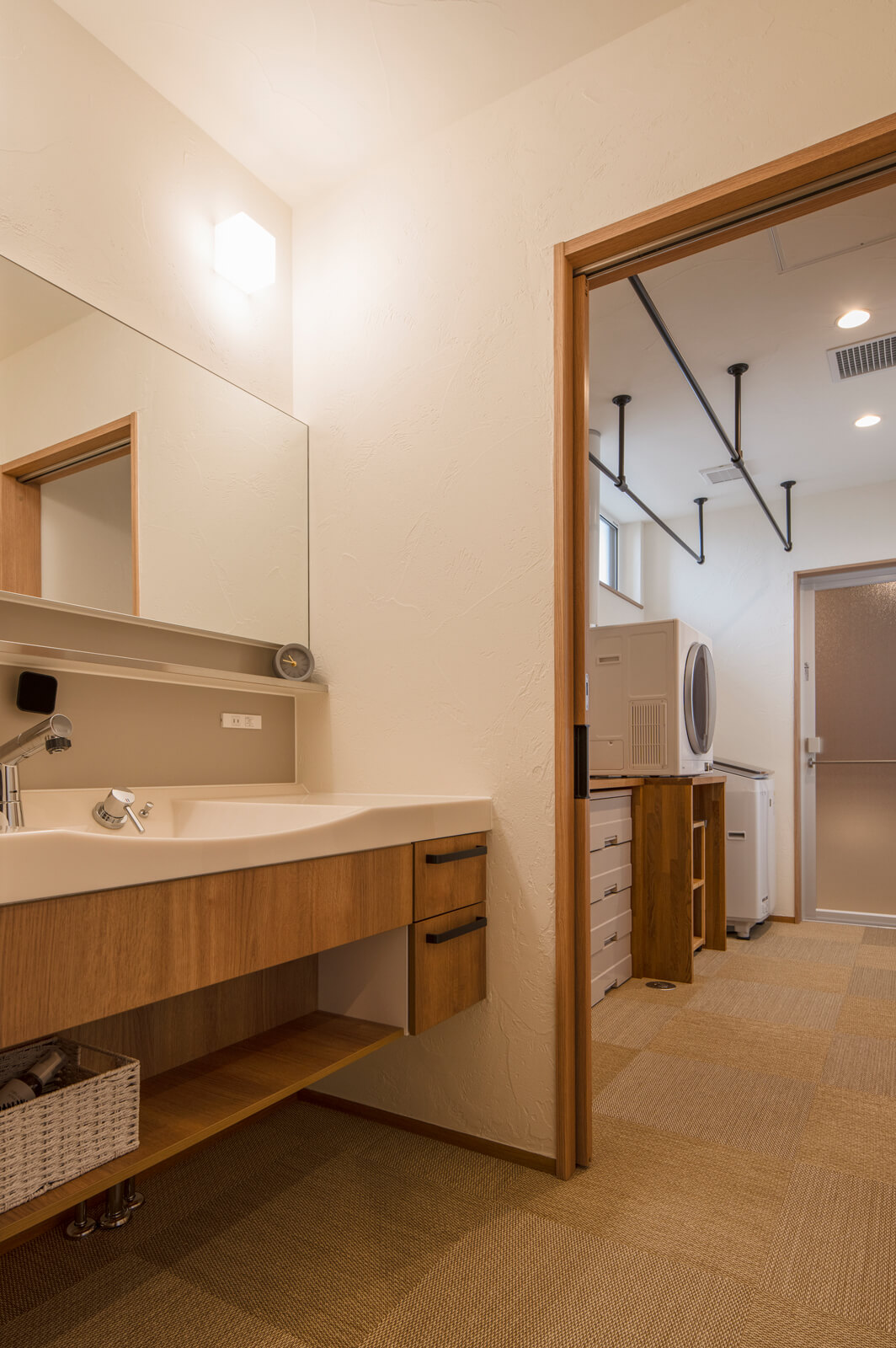 水まわりには調湿効果のある珪藻土を採用。廊下から洗面スペース、ランドリールームからキッチンへとスムーズに回遊できる動線を確保している。「ウォークインクローゼットとも近く、洗濯後の片付けがスムーズです」と奥さん