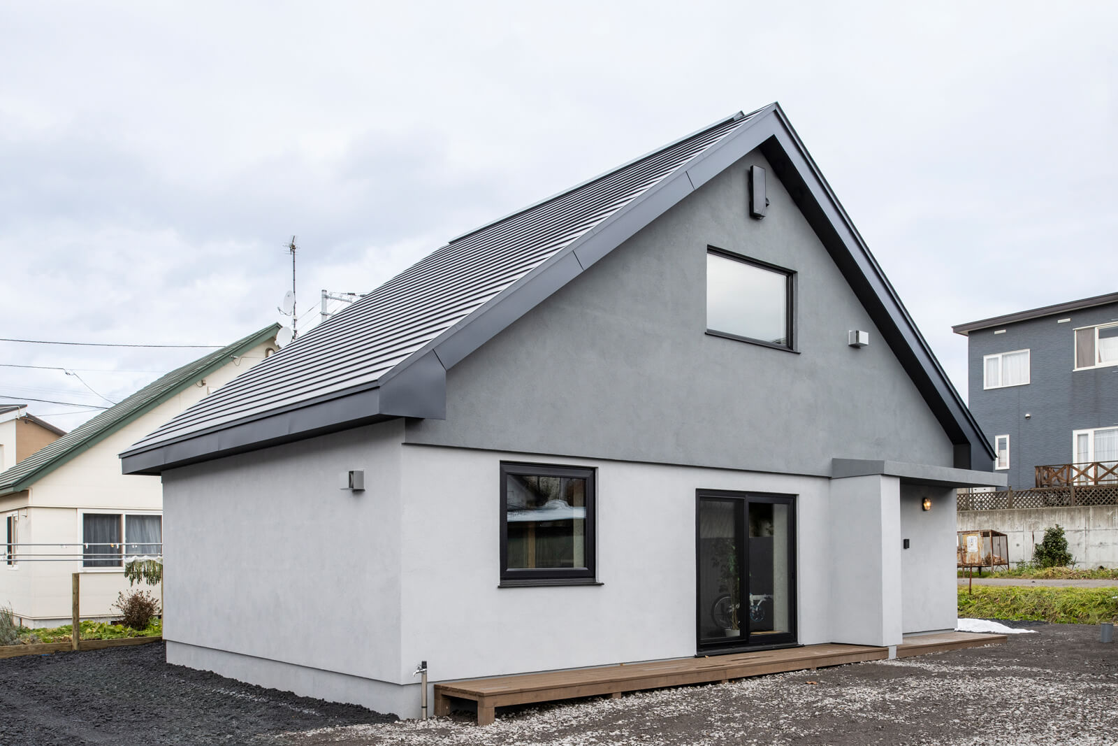 ブロック住宅の象徴ともいえる大屋根をそのまま生かしながら、シャープな雰囲気に一新した外観。屋根の形状は、雪の重みを軽減し、雨水の排水を促進する役割も果たしている