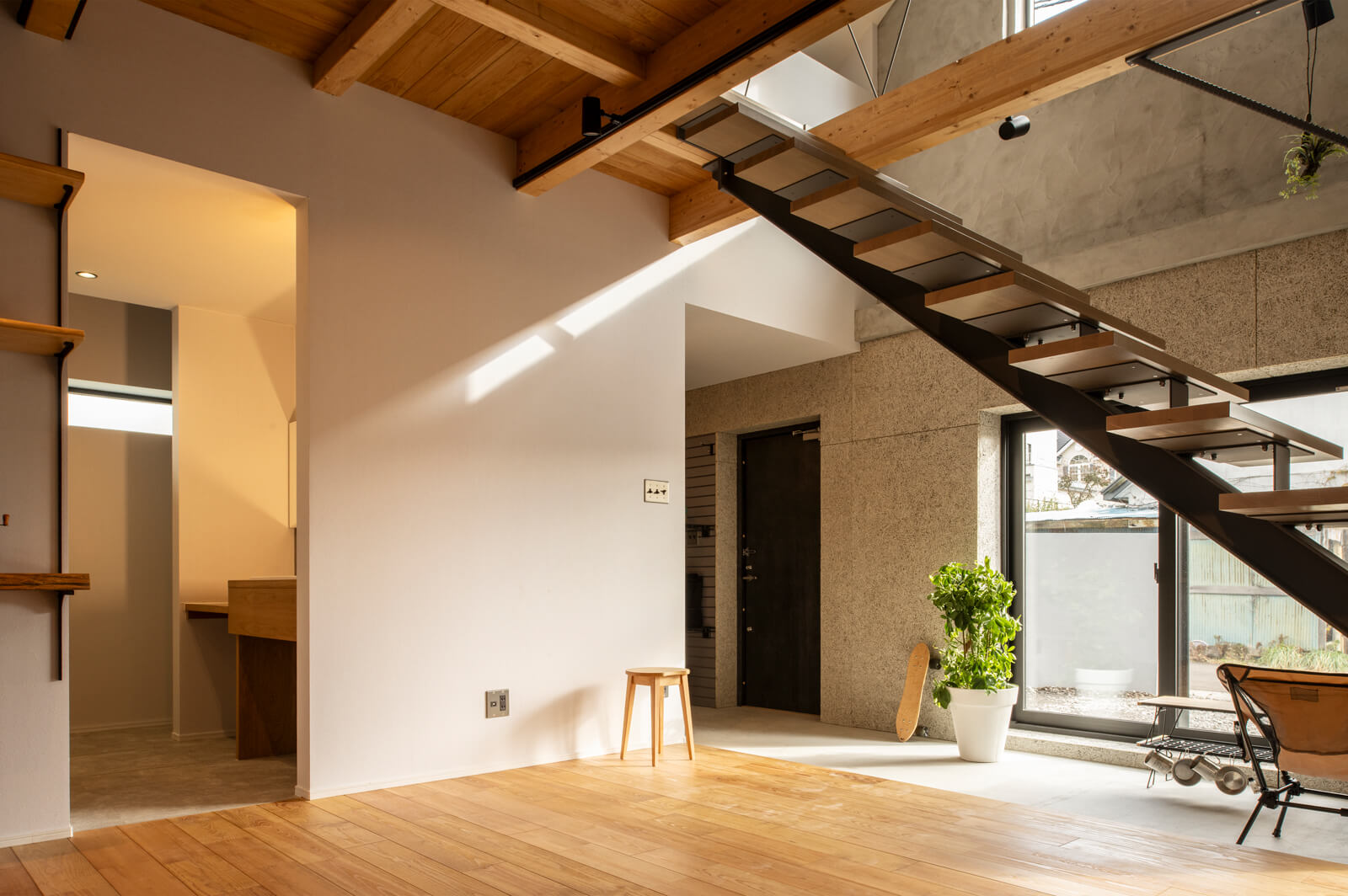 リビングから玄関を見る。玄関右手奥へ進むと水まわり、その動線はリビングにもつながる。現しの梁や柱は、すべて新材を採用している