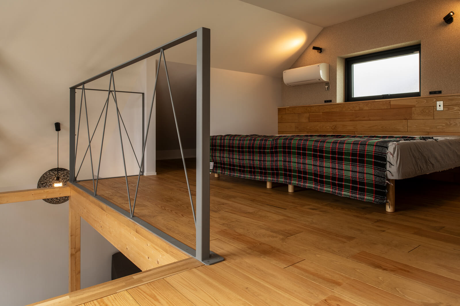 吹き抜けに面した2階ホールは、そのままベッドルームに。空間の広がりと、こもり感を同時に味わえる休息スペースに仕上がった