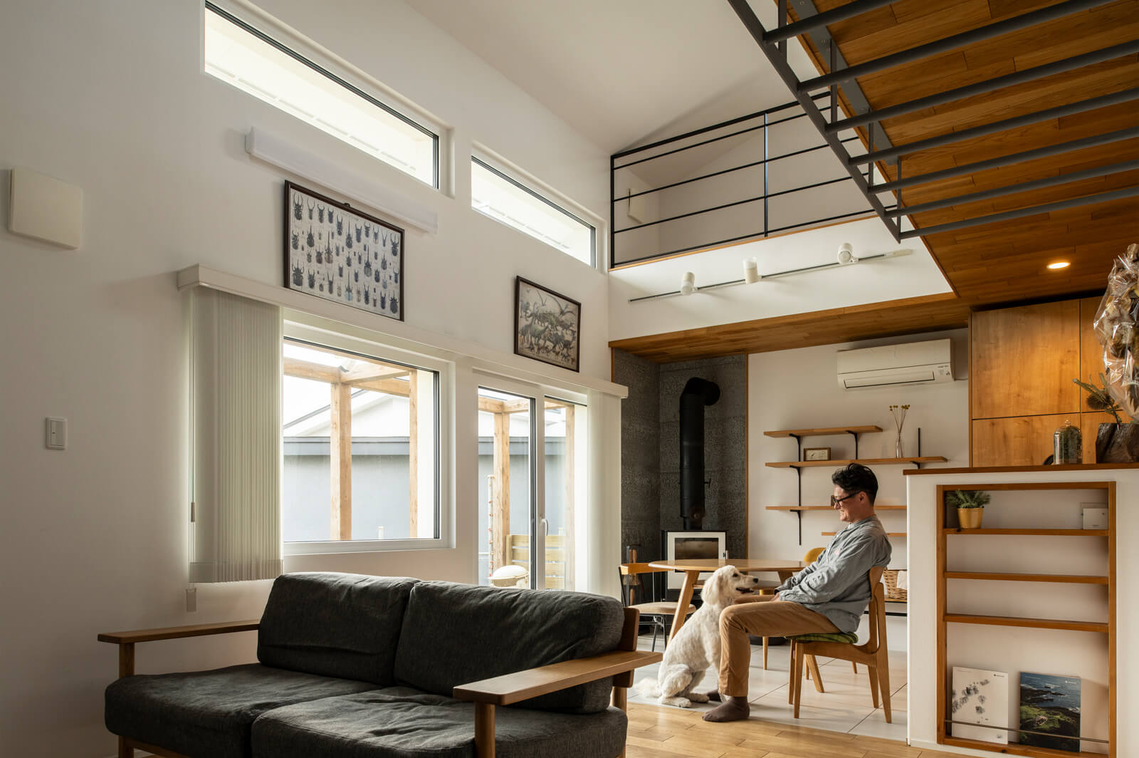 高い吹き抜けとたくさんの窓を設け、明るく開放的なLDKを実現。リビングを吹き抜け越しに見下ろす2階ホールは、耐震補強の役割も兼ねる。リビングの床と天井の一部には、道産ナラ無垢材を採用した