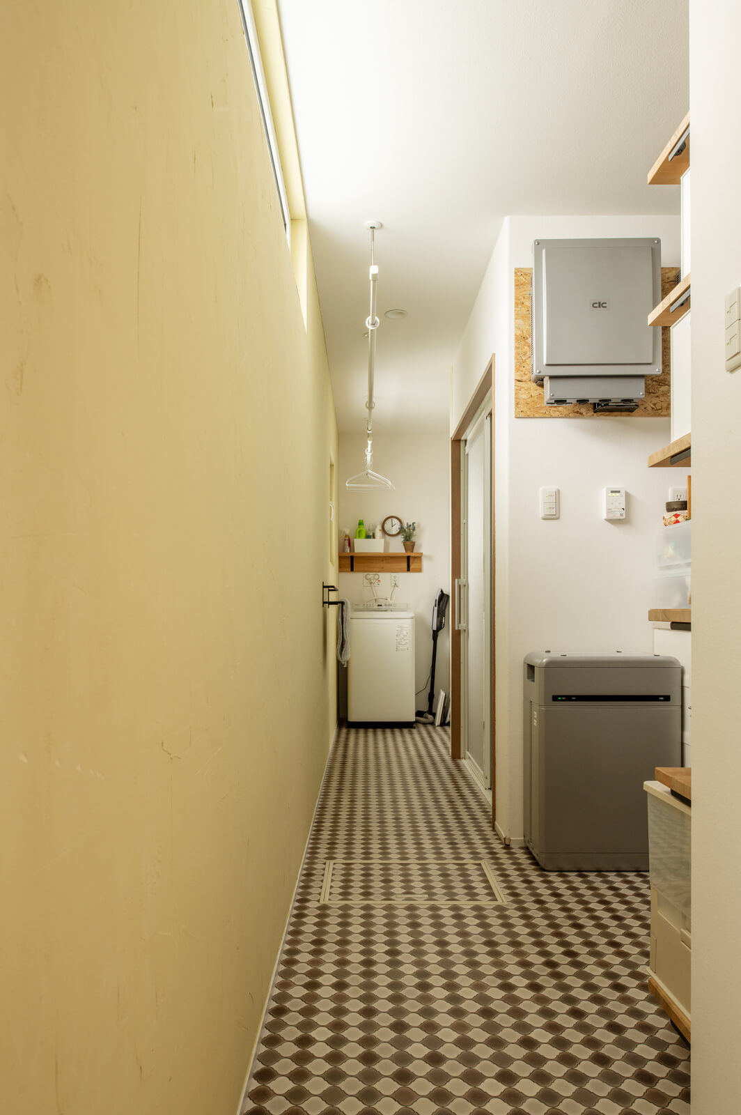 キッチンから裏動線でつながる水まわり。突き当たりは洗面・脱衣室。漆喰の壁は夫婦でセルフビルドした