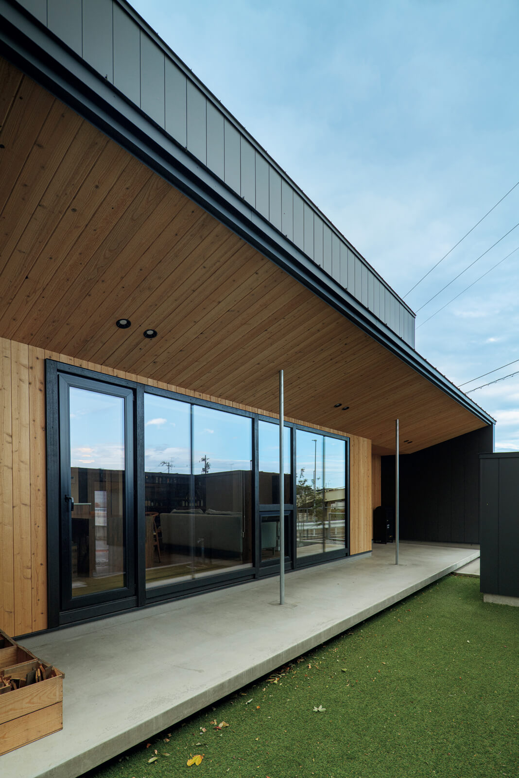 玄関ポーチから続く幅約1.8ⅿのテラス。軒の出も約1.8ⅿあるので、夏は日射を遮り、冬は日射を室内に導く。庭は人工芝を敷いて雑草が生えにくいようにしている