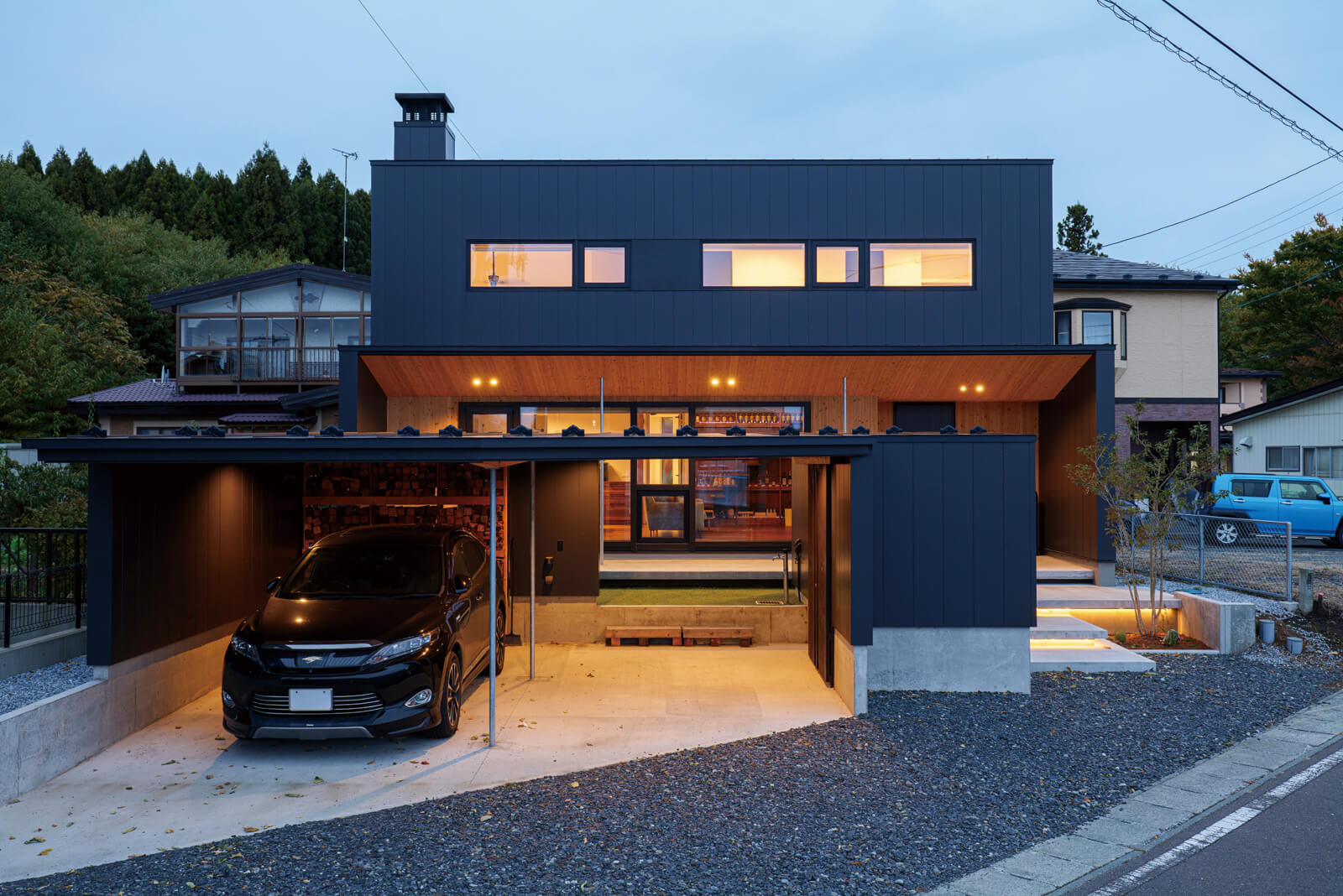 黒のガルバリウム鋼板と国産スギ無垢材を組み合わせた外観。ガレージが目隠しになっていて、通行人からの視線を遮っている