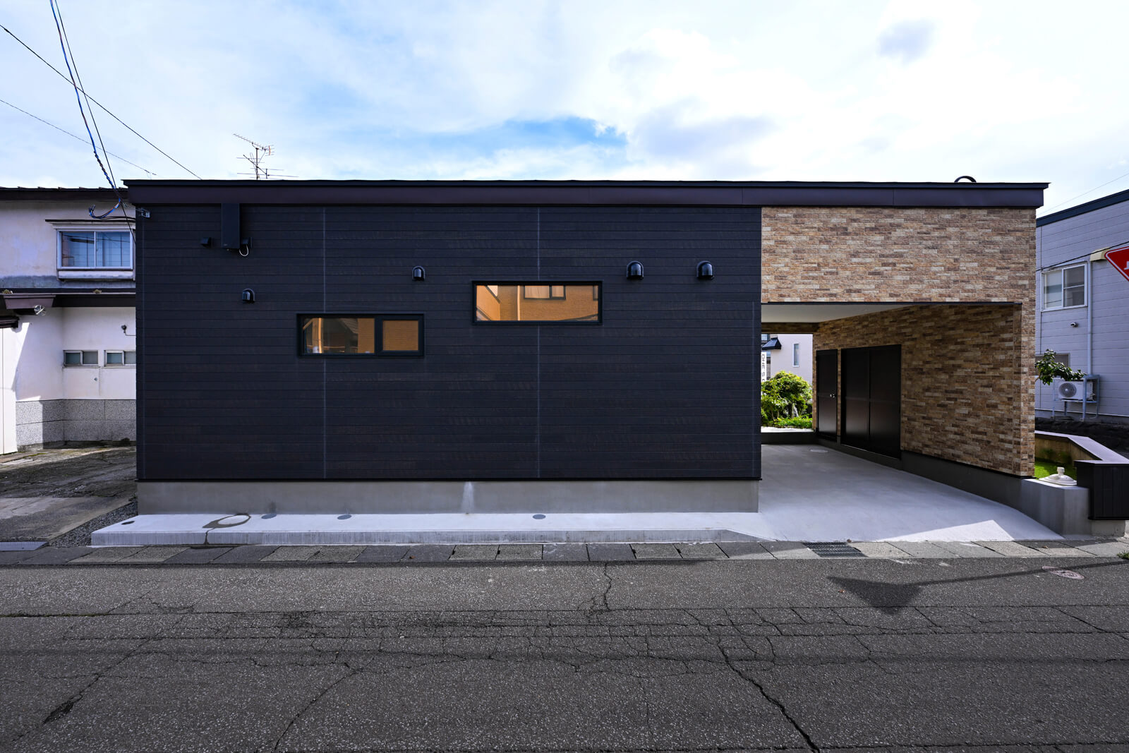 黒とタイル調の窯業系サイディングでシンプルに仕上げた外観。もとは8畳の和室があったスペースにガレージを設計している