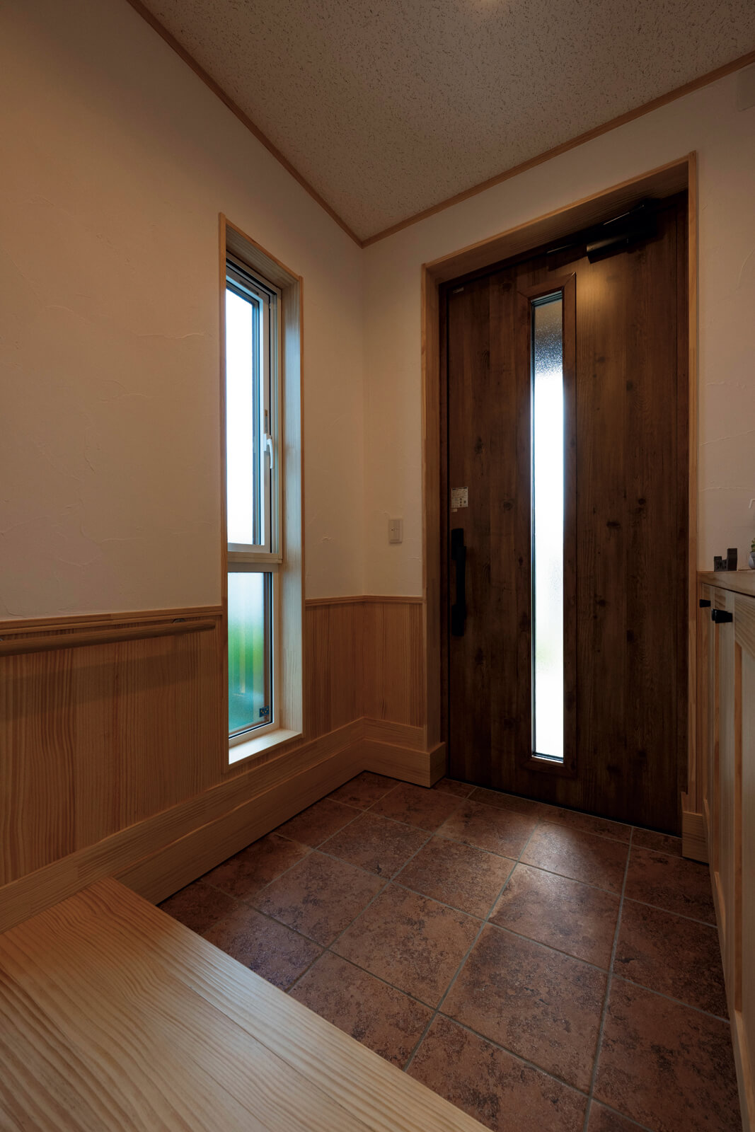 約4帖の玄関。縦に長い窓を配置してあるので、陽が出ている間は足元まで明るい