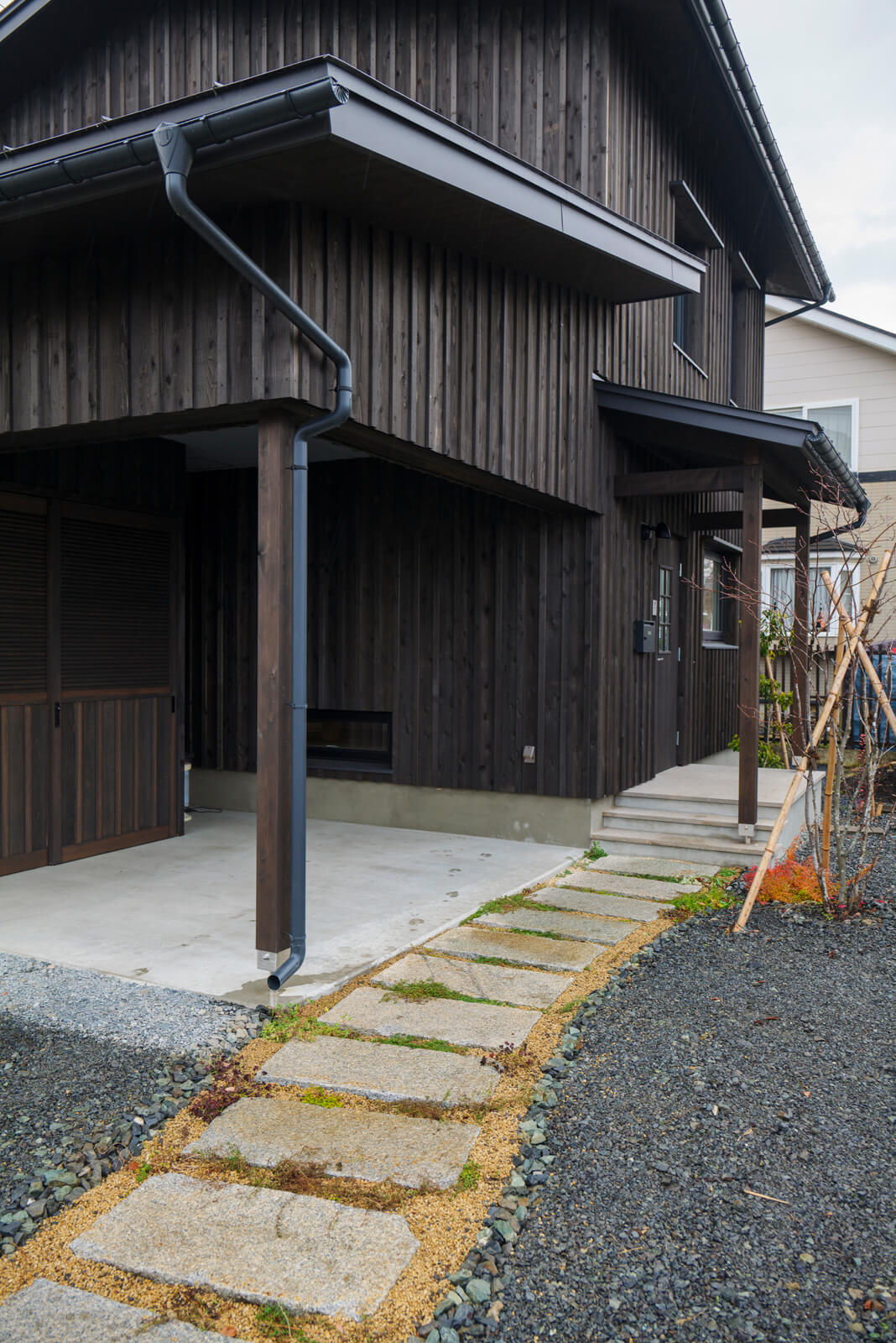 アプローチの飛び石には御影石、玄関ポーチには札幌軟石を使用。ご夫妻の要望だった「和風の空間」を玄関から表現している。ジュンベリーの木を植えて、お子さんと果実の収穫を楽しんでいる