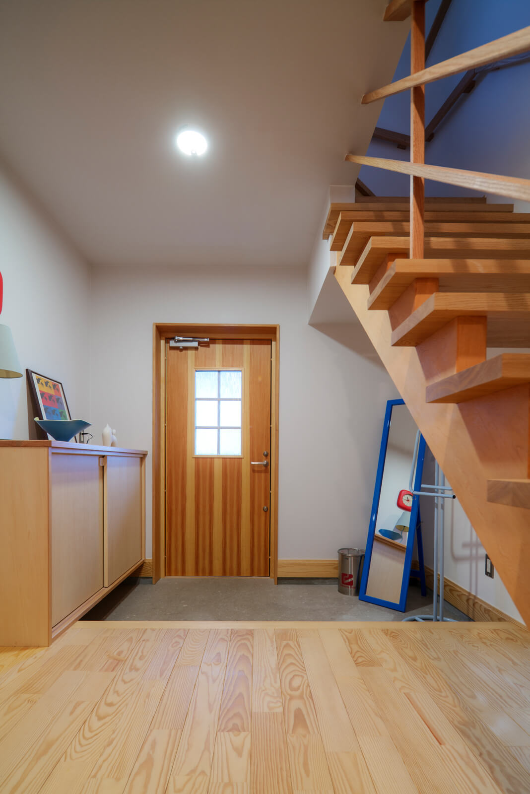 タイル張りにした約3帖の玄関土間。1階の床は県産アカマツ材を使用した。針葉樹の特徴である柔らかい肌触りと温かみが、帰宅した家族に安心感を与える。スウェーデン製の断熱ドアはパイン材で、床材とも調和する