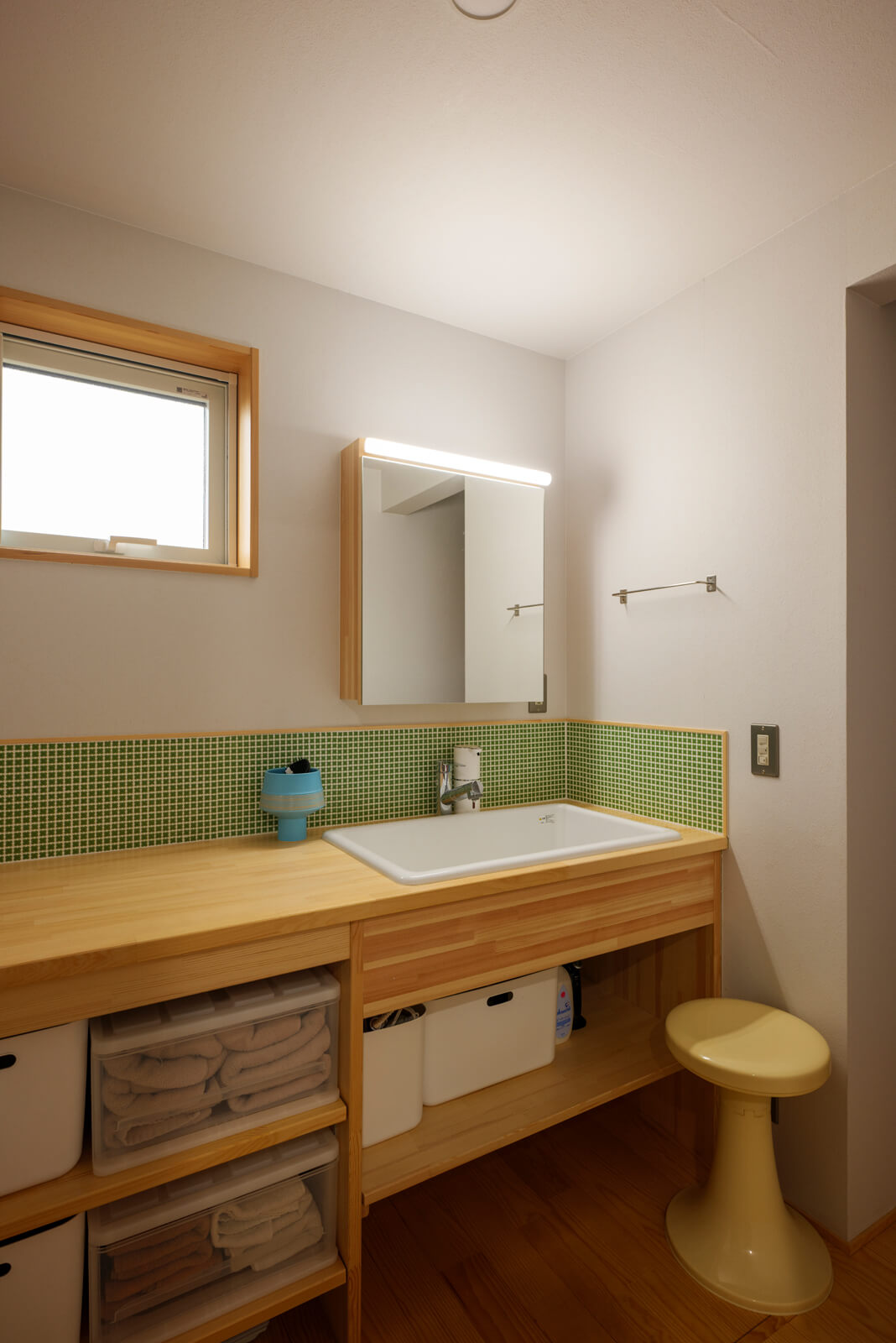 造作洗面台のパステルグリーンの小さな花形をしたタイルは奥さんのチョイス