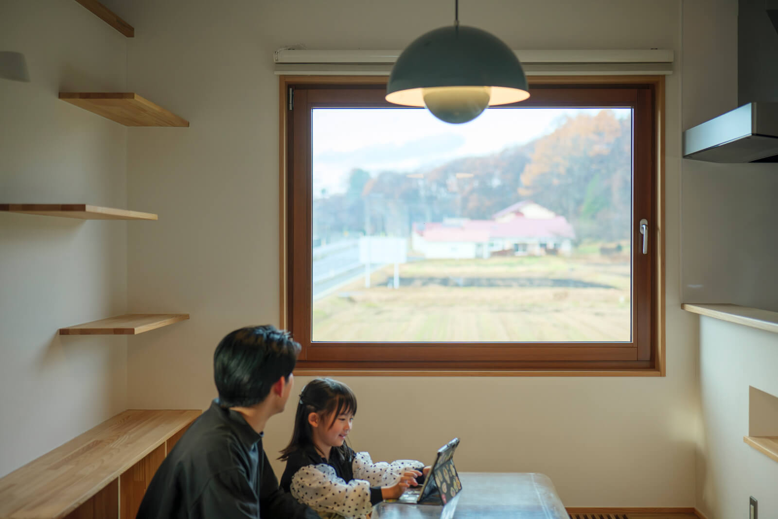 スギ材を使ってオーダーメイドの木製サッシも設えた。隣地の田園風景や裏山を切り取るピクチャーウィンドウとしての役割も果たす