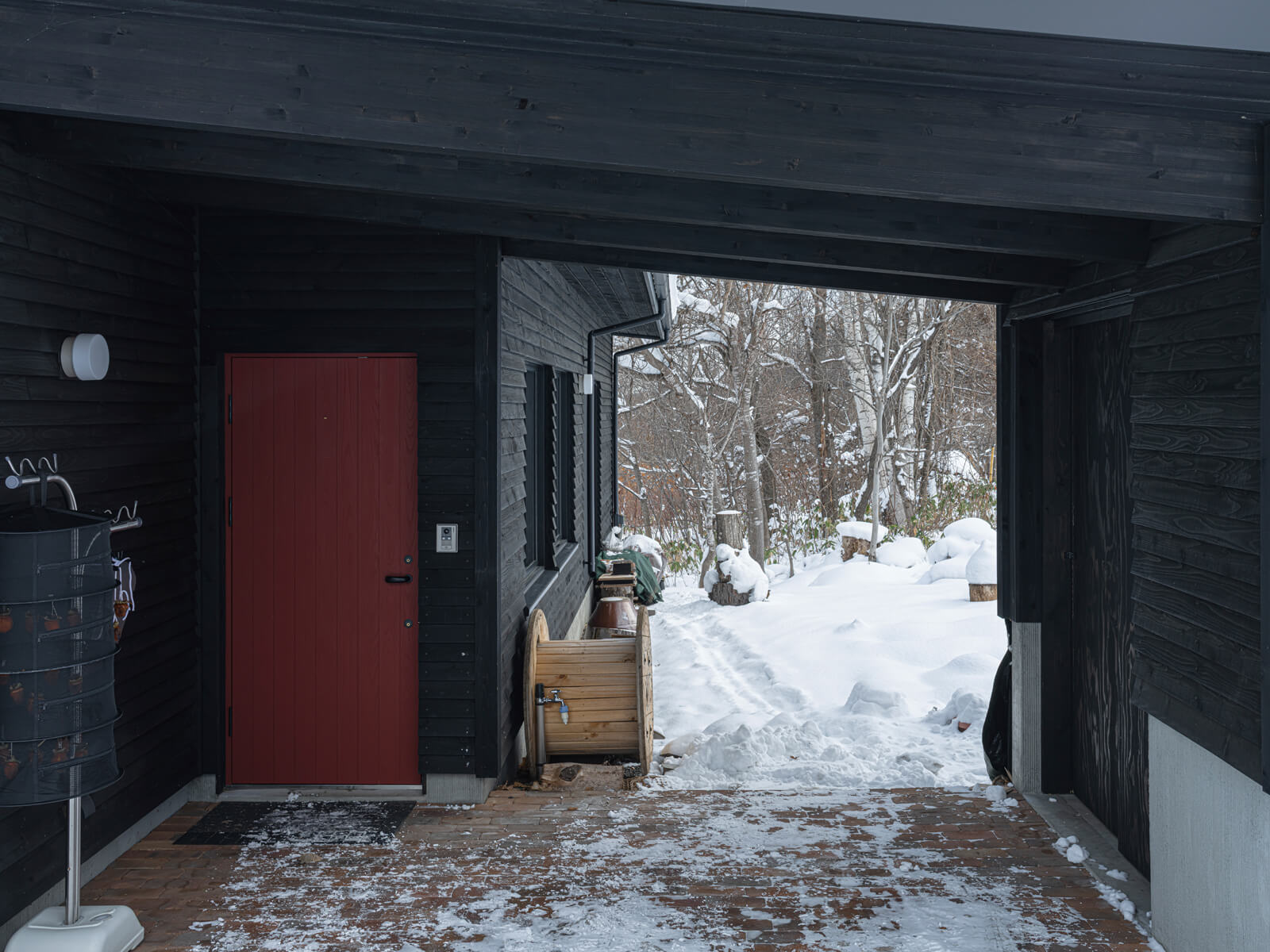 外物置と一体的に設計した造作の屋根付きカーポートは、玄関アプローチを兼ねる。車椅子の息子さんが雨や雪に濡れずに車から室内へ移動できるよう、動線とつくりにこだわった