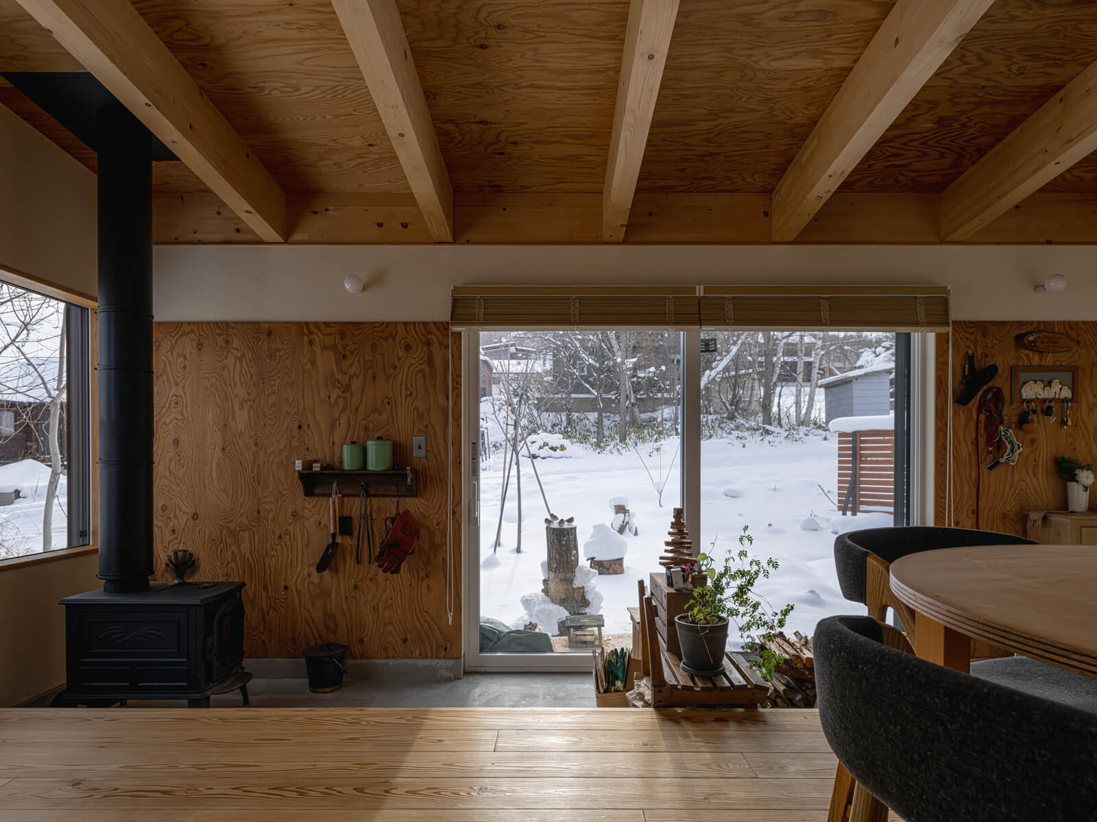 「庭を眺めながら日向ぼっこをしたい」という希望を叶えた土間のあるLDK。冬は掃き出し窓のすぐ外に設置したバードテーブルに三々五々集まってくる野鳥たちの姿を、室内から眺めるのが日課に。内と外のシームレスなつながりが、日々の暮らしに多様な楽しみをもたらしている